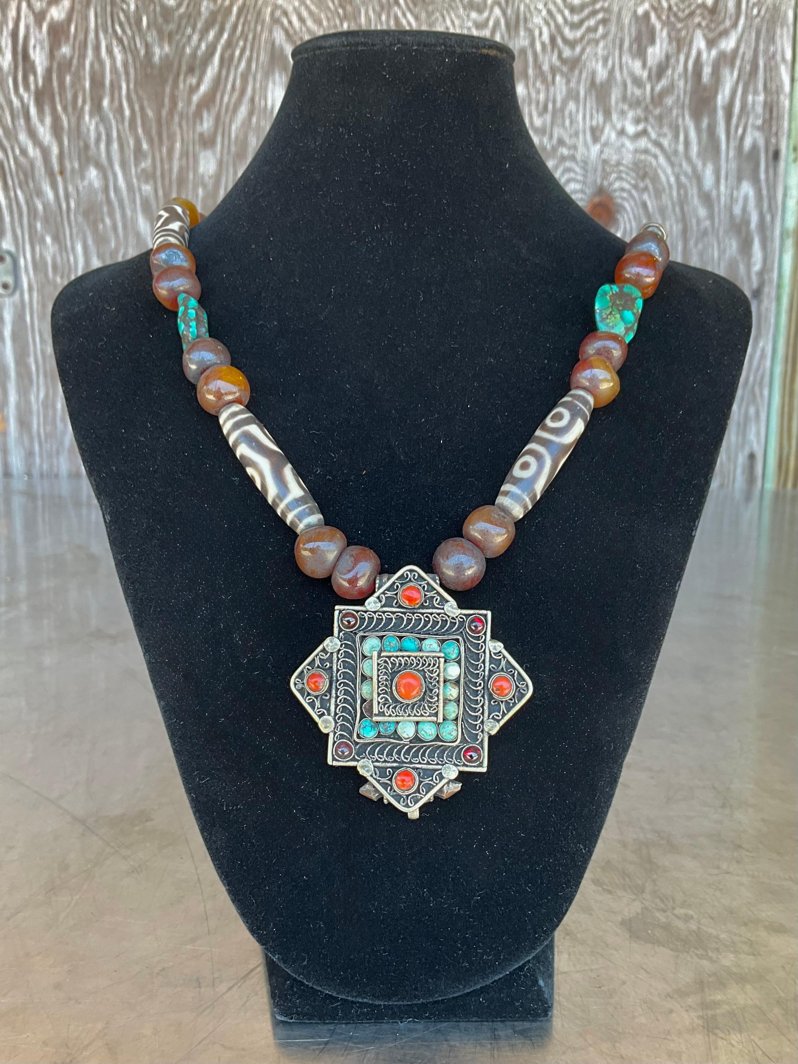 Diese tibetische Perlenkette im Vintage-Stil mit Türkis ist ein eindrucksvoller Ausdruck von Himalaya-Kunstfertigkeit und spiritueller Symbolik. Die mit traditionellen Techniken handgefertigte Halskette besteht aus kühnen, klobigen Perlen in