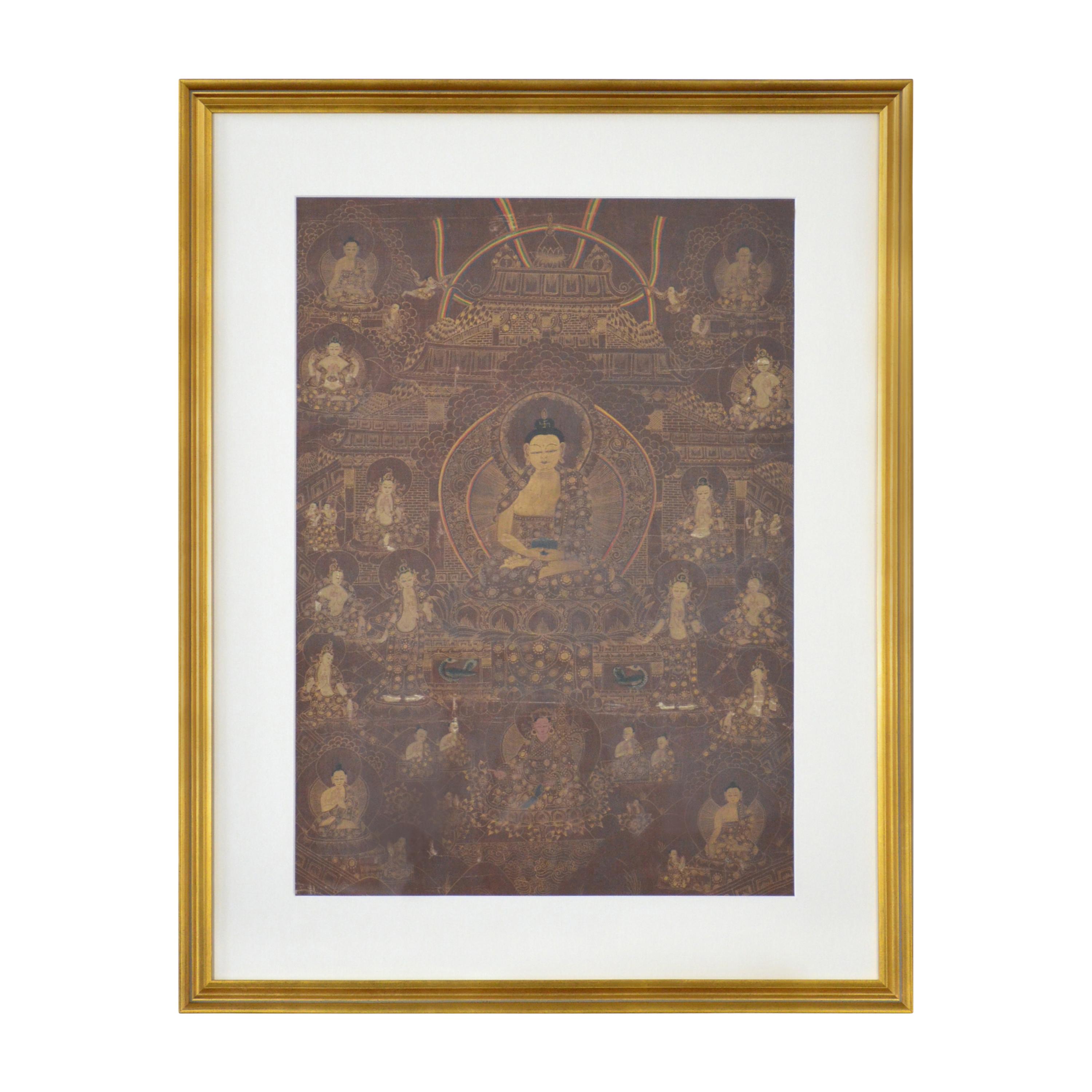 A vintage Tibetan hand-painted Thangka painting on canvas depicting Buddhist deities, in gilded frame. Created in India during the mid 20th century, this painting on canvas, called a Thangka, showcases a monochrome palette made of brown and beige