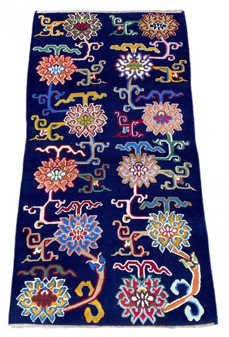 A beautiful vintage Tibetan rug, handwoven circa 1960 with a meandering design of linked lotus leaves on a deep indigo field. Lovely wool quality and great secondary colours.
Size: 1.75m x 0.91m (5ft 9in x 3ft)
This rug is in good condition with