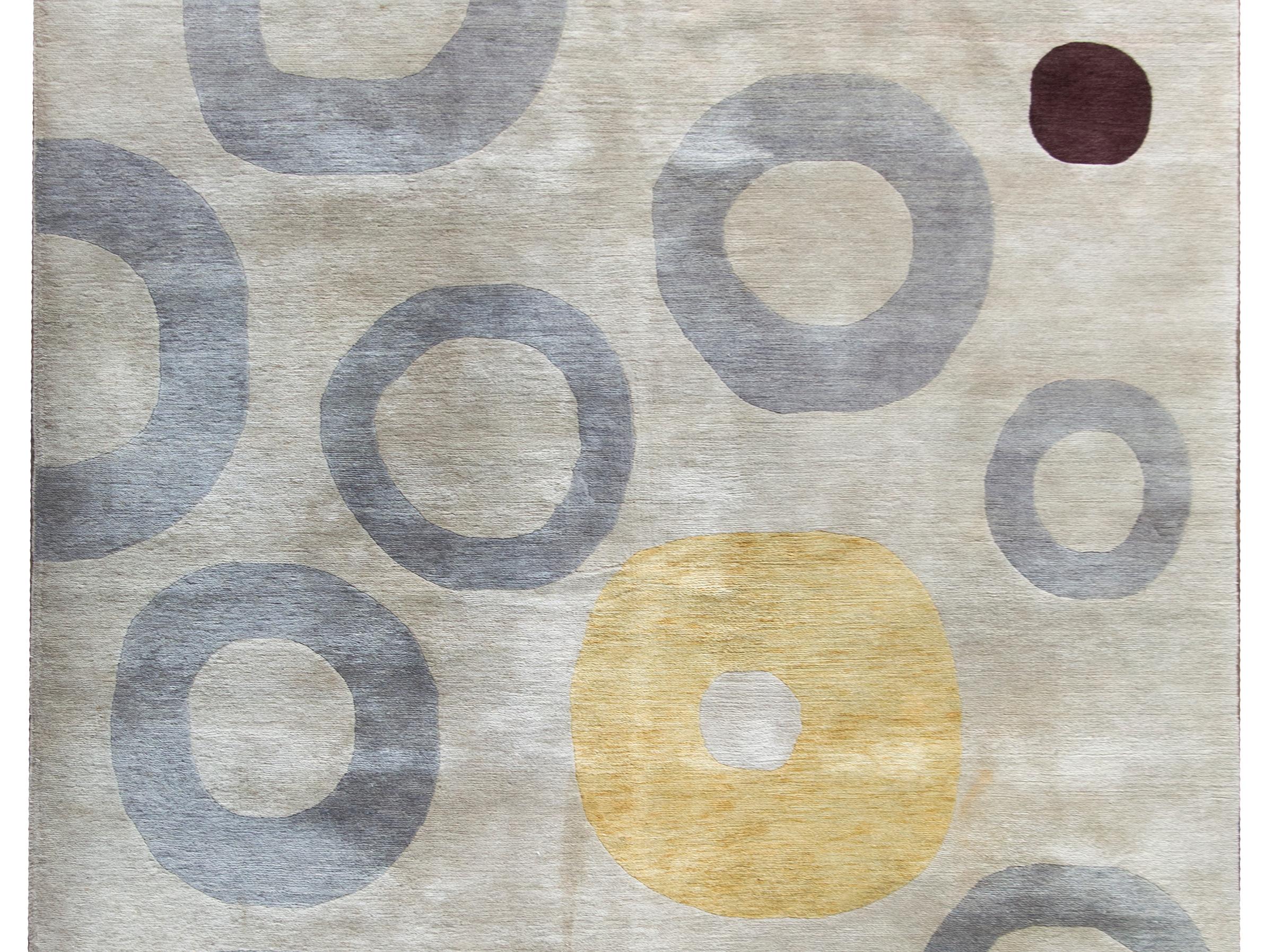 A striking vintage Tibetan hand-knotted wool rug with two dark red circles and several gray and yellow circles against a silver ground, and with no border.