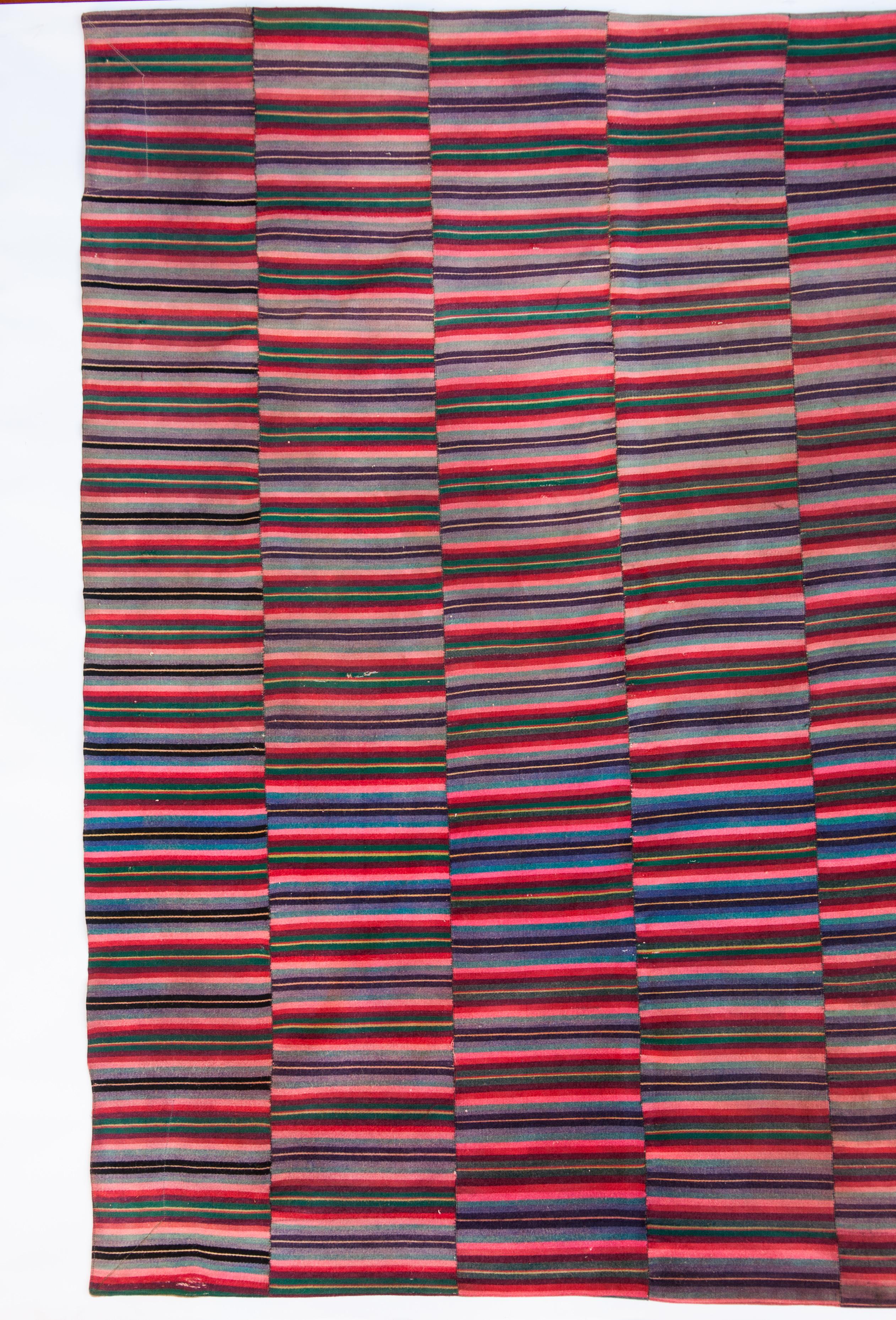 Vintage Tibetan style blanket from Bhutan. Wool, mid-20th century.
This striped blanket comprises 12 narrow handwoven woolen panels stitched together, with a small tie dyed square in the bottom corner. The blanket is lightly felted.
Please note