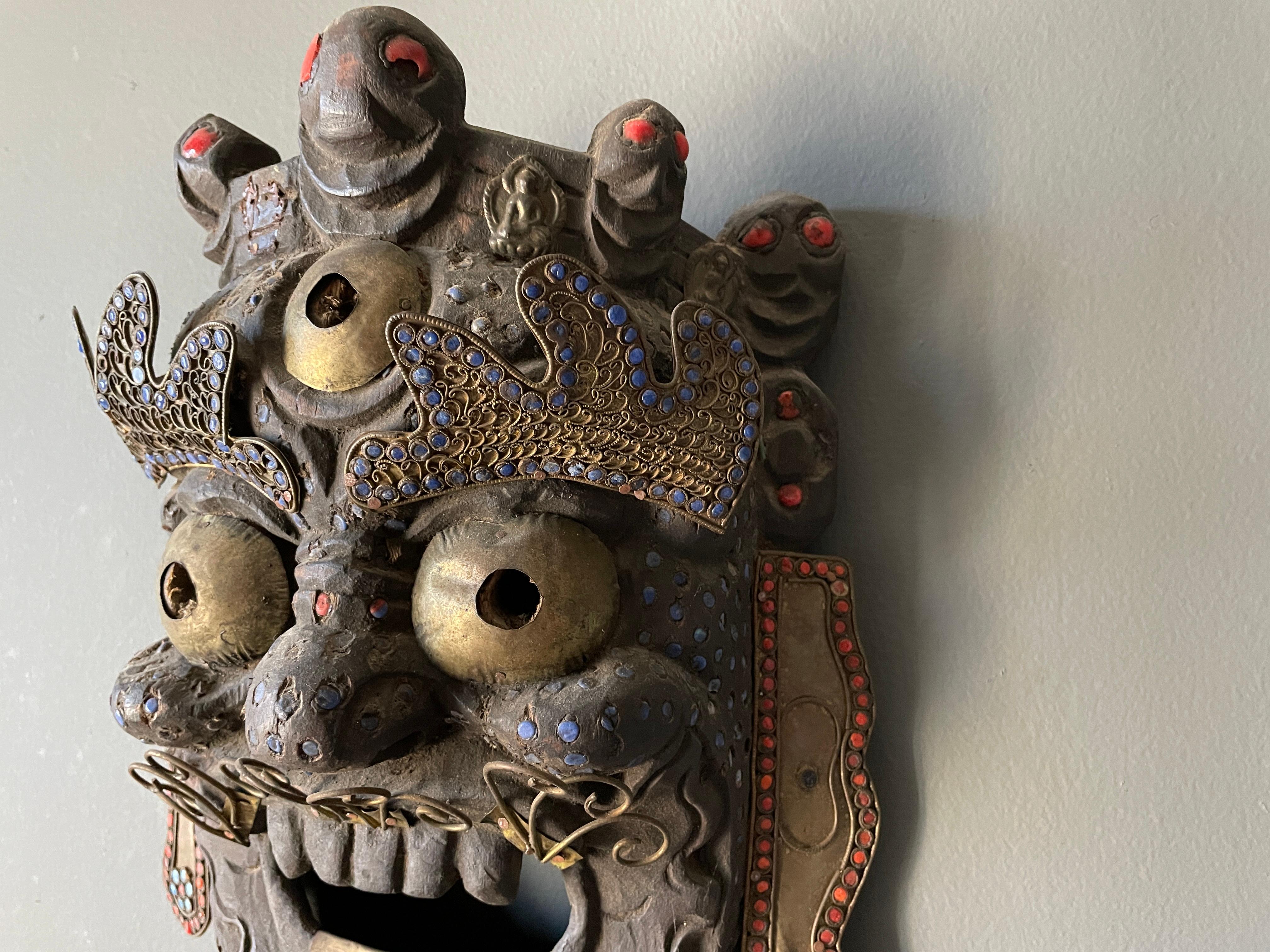 Vintage Tibetan style hand carved tribal mask. Deep, vibrant colors with brass accents. A wonderful accent piece for any room.