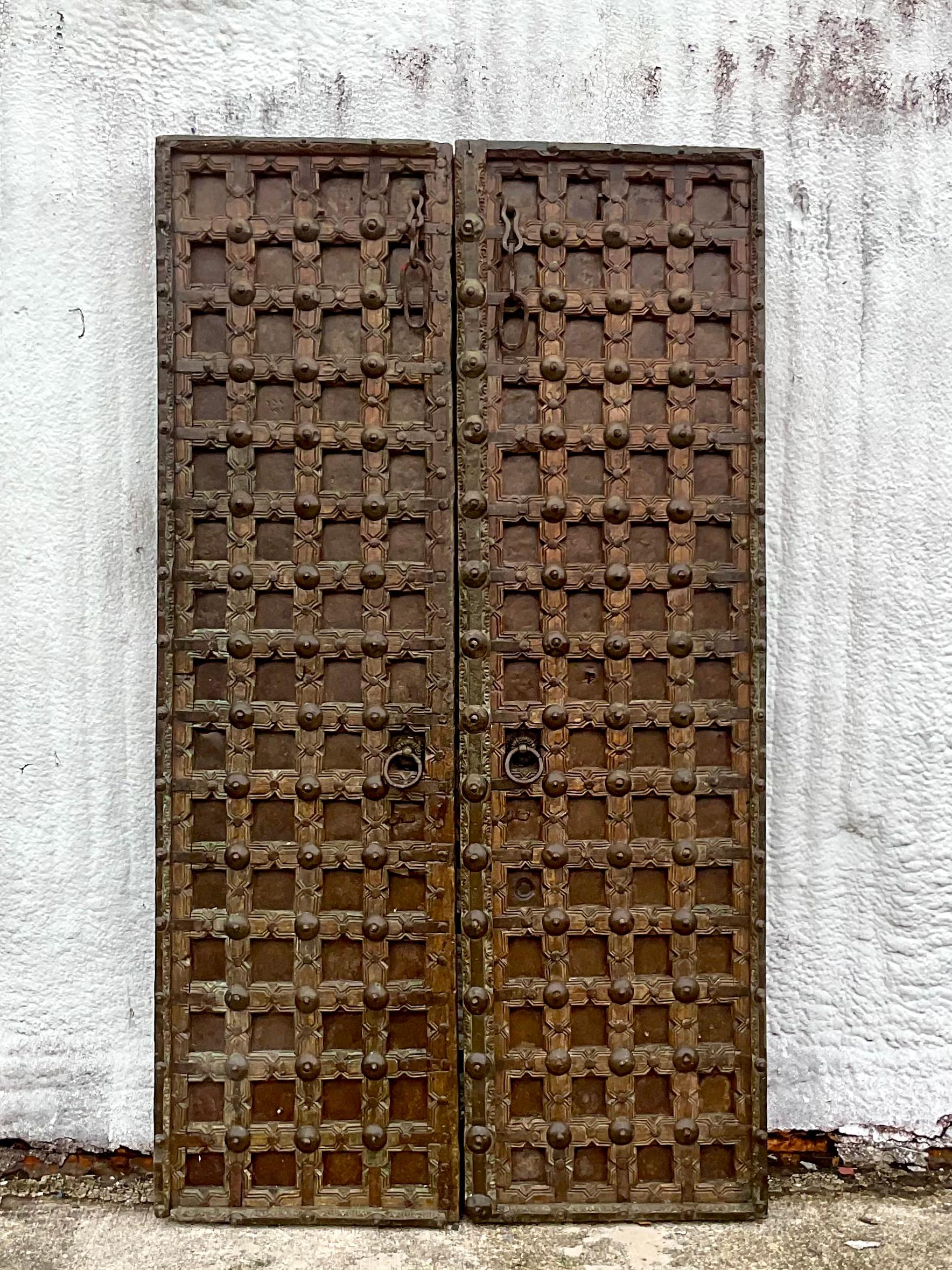 Striking vintage temple door. An iconic Tibetan design with heavy slab wood and hand forged metal. Heavy duty handles and door pulls. Acquired from a Miami estate.