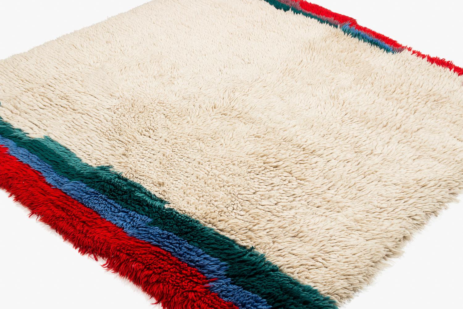 Questa coperta di lana tibetana lavorata a mano è un raro pezzo vintage. Particolarmente affascinante per il suo pannello finale verde, blu e rosso. Il suo spesso pelo veniva usato per dormirci sopra o sotto durante le fredde notti dell'Himalaya. In