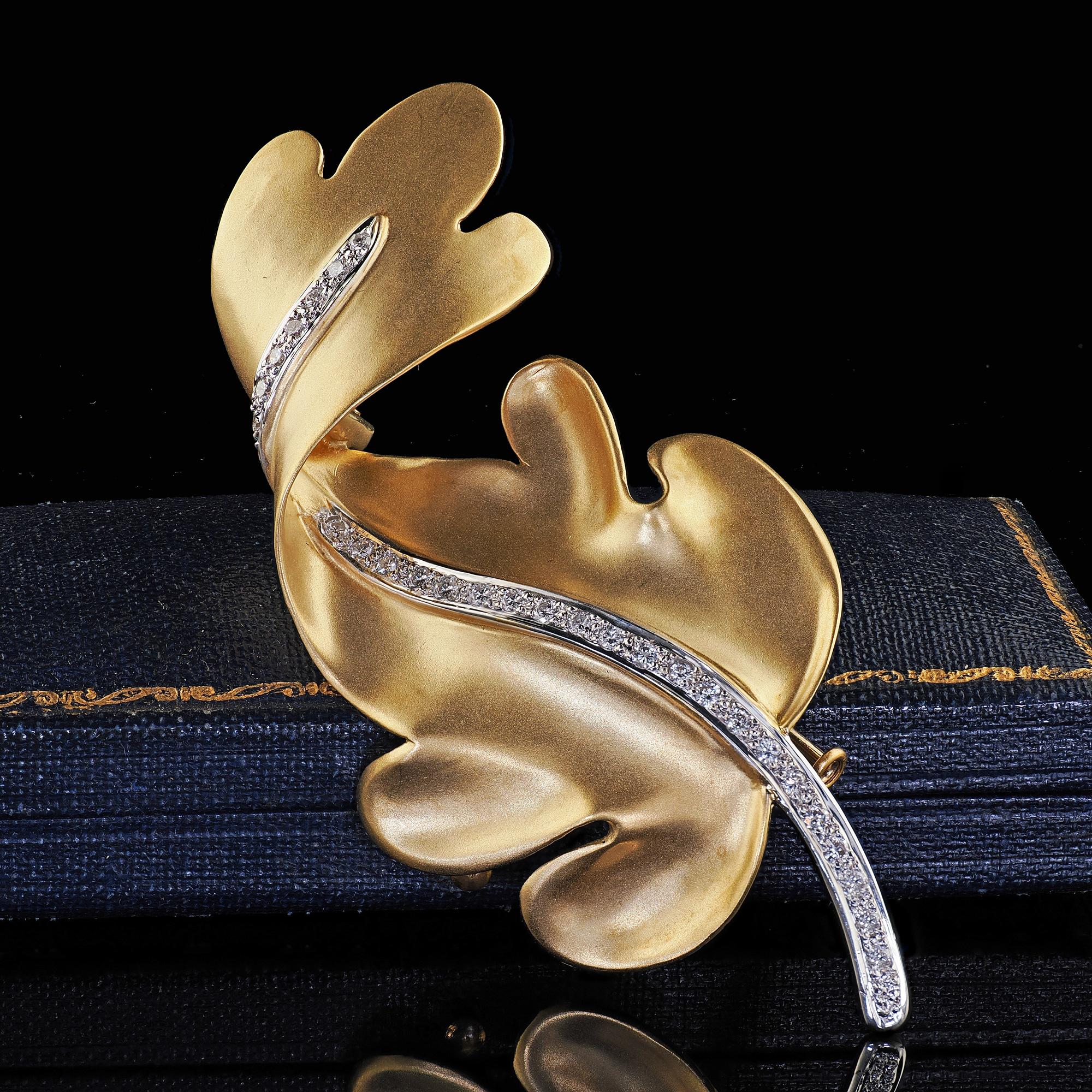 Beautiful Vintage Tiffany and Co 18K Yellow Gold and Platinum Diamond Leaf Pin. This gorgeous Tiffany and Co leaf pin is crafted in 18k yellow gold and platinum. This pin features a row of beautiful diamonds set in the center stem of the leaf