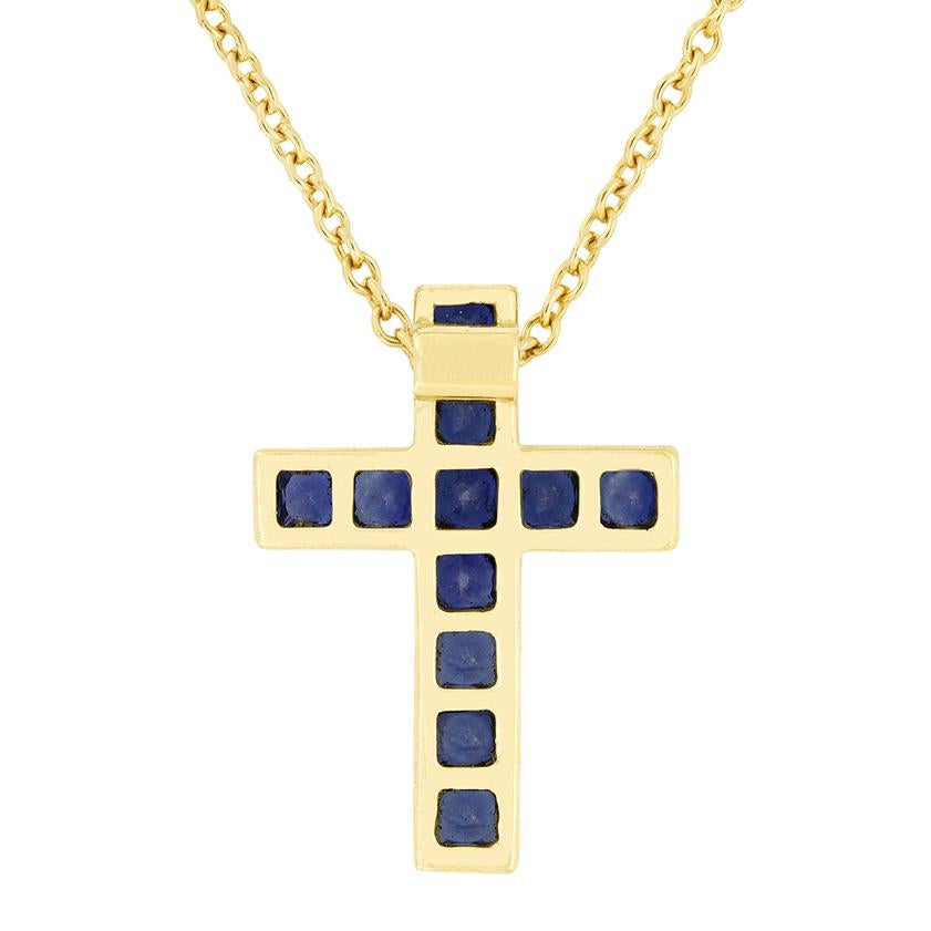 From the designer Tiffany & Co. comes this beautiful Latin cross pendant. This vintage piece dates to the 1970s and features a total of 0.60 carat in square cut sapphires, set into 18 carat yellow gold. The cross measures 16mm in length and 11.5mm