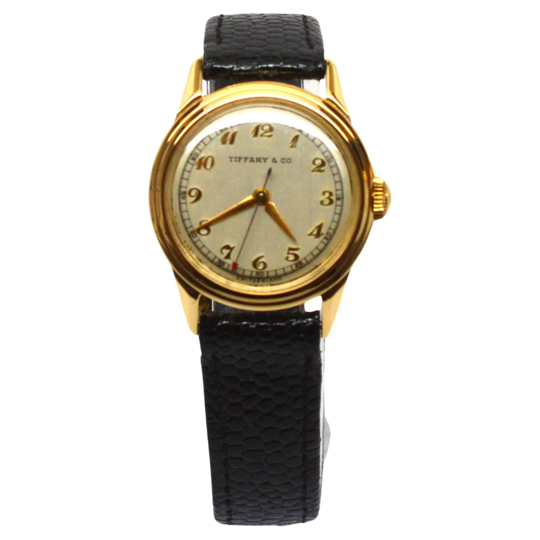 Genießen Sie diese selten gefundene Vintage 14 Karat Gelbgold Tiffany & Co. Armbanduhr um 1945 mit original Tiffany & Co. Box. Diese luxuriöse analoge Vintage-Uhr ist ein Klassiker mit schönen Linien und einfacher Funktionalität.  Das 30-mm-Gehäuse