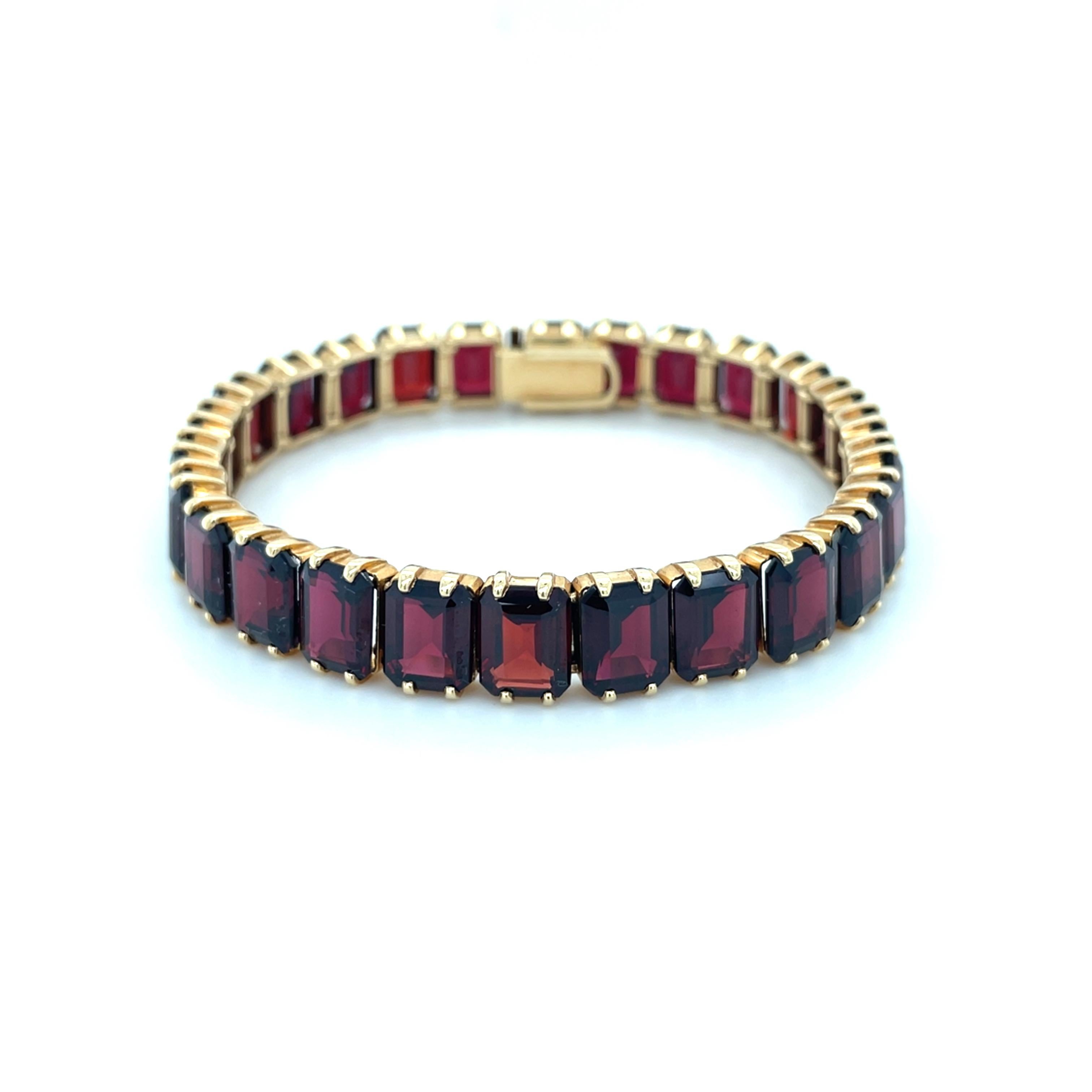 This is a classic Tiffany & Co. link bracelet containing 26 emerald cut garnets measuring approximately 9.20 x 7.00 mm. 

Metal: 14 karat yellow gold
Stamp: TIFFANY 14K 
Measurements: 7 1/2 inches long, 10.00 mm wide
Gross weight: 38.80 grams