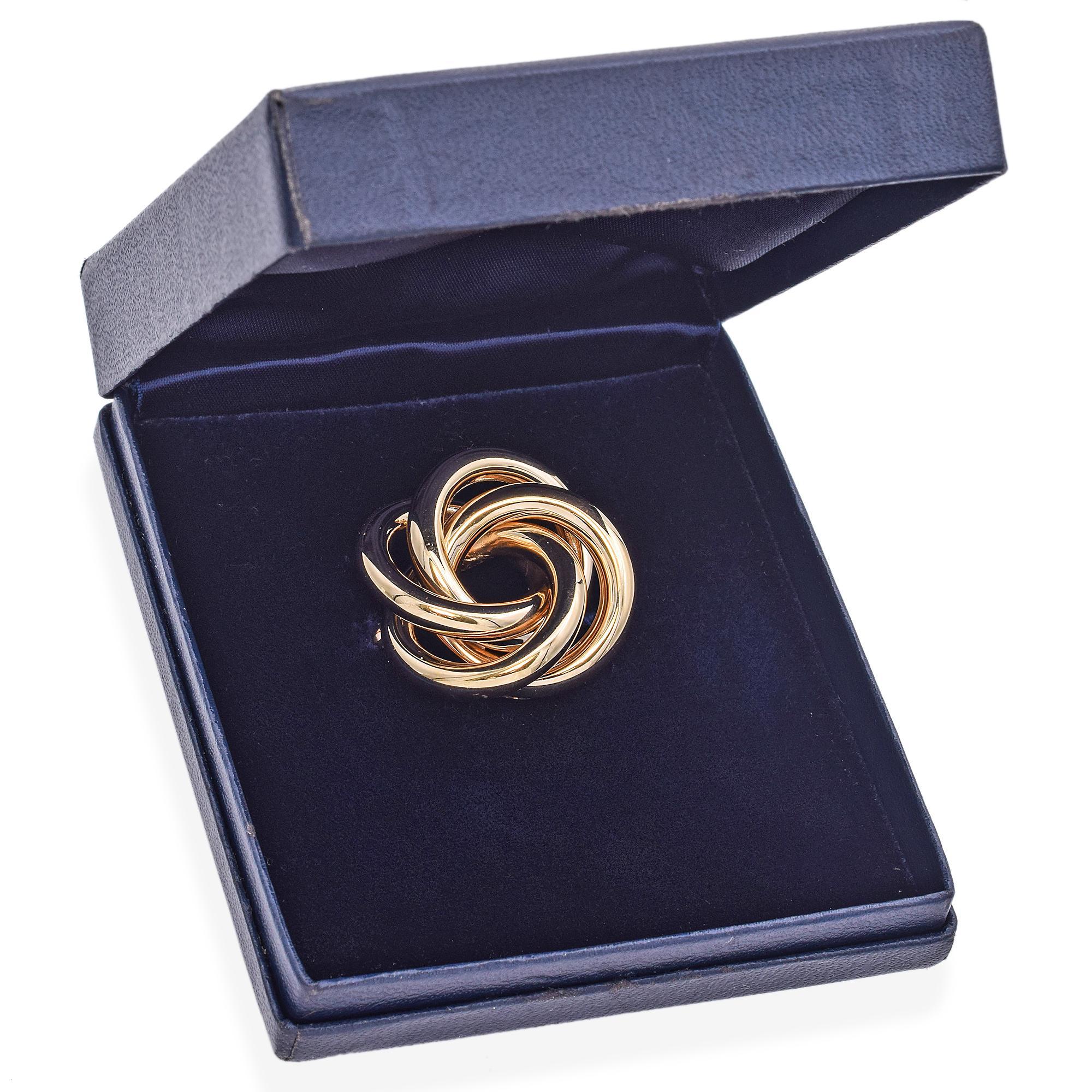 Diese von Tiffany & Co. gefertigte Vintage-Brosche zeichnet sich durch ihr charakteristisches, ineinandergreifendes Design aus glänzendem 14-karätigem Gold aus.
Die glatten, geschliffenen Loops ergeben ein harmonisches und raffiniertes