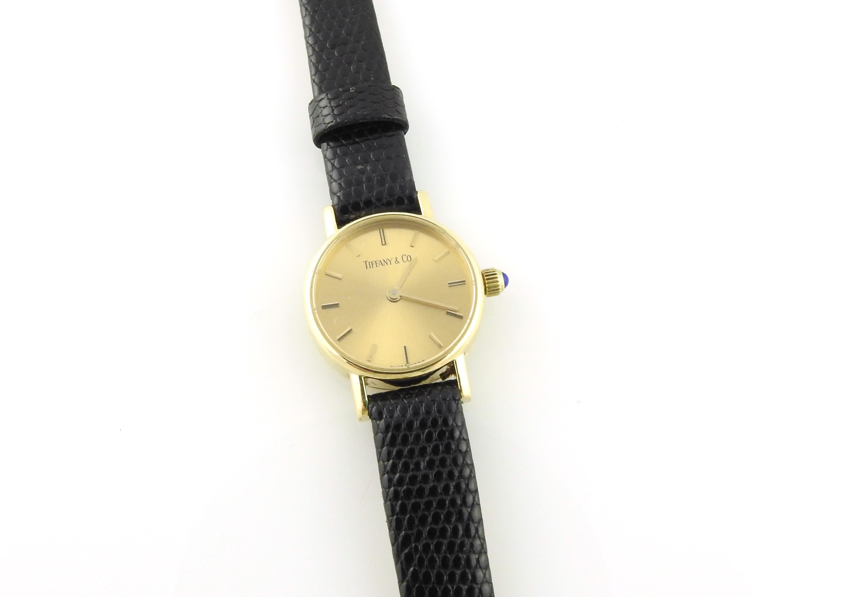 Tiffany & Co. 14K Yellow Gold Petite Ladies Watch

This vintage classic Tiffany & Co. Ladies watch is set in 14K yellow gold.

Case is approx. 19mm in diameter with a gold dial and gold markers. Gold crown with cabochon sapphire.

Band is NOT