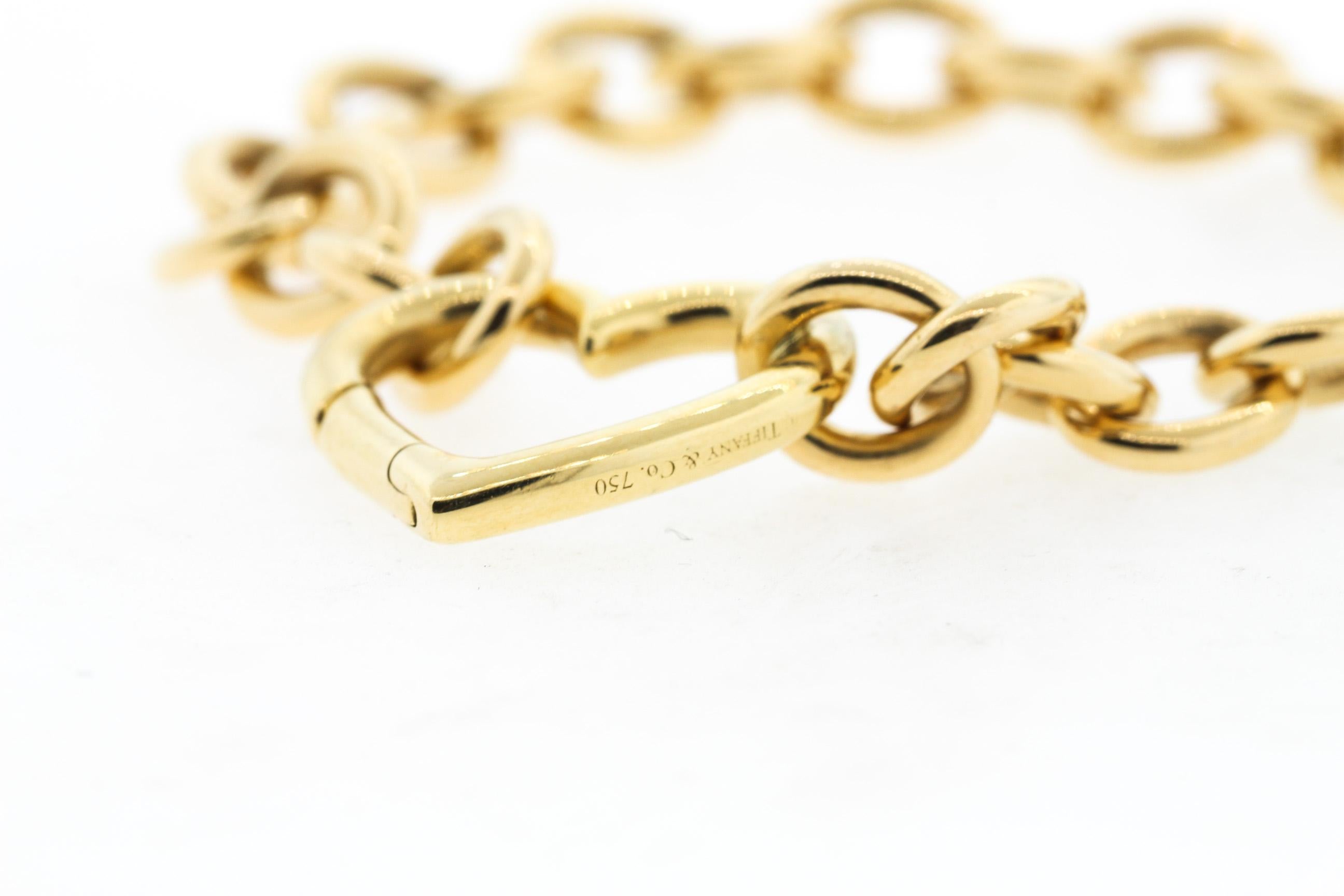 A handsome Tiffany & Co. 18k gold link bracelet with a large heart clasp, circa 1990. Sweet and sentimental with a nice substantial link. The heart has a push mechanism that allows you to wear the bracelet on any link. A Tiffany carabiner type