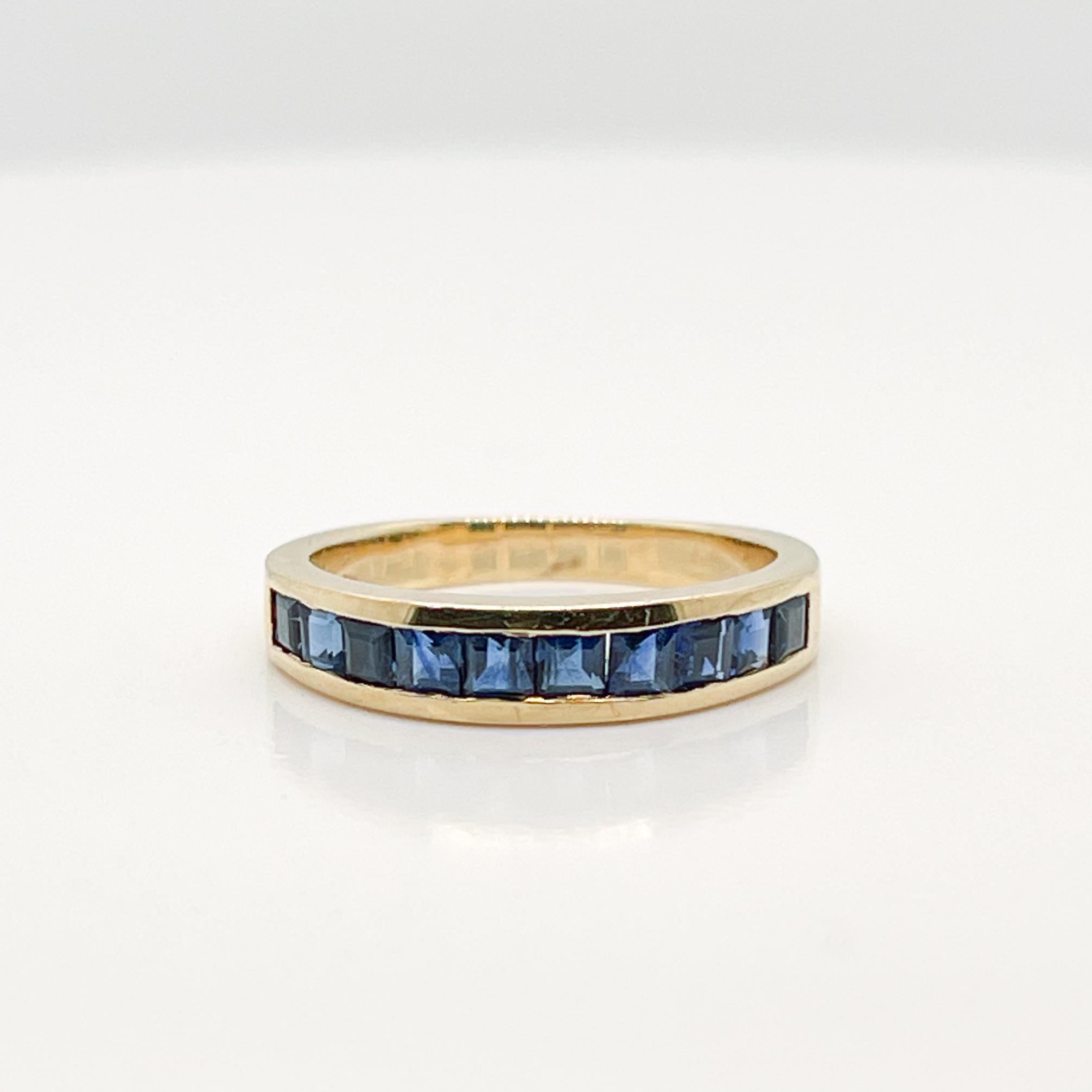 A very fine gold & sapphire half eternity band ring.

By Tiffany & Co. 

In 18 yellow gold.

With channel set square-cut faceted sapphires to the top and a solid band to the reverse.

Simply a wonderful ring by Tiffany & Co.!

Date:
20th