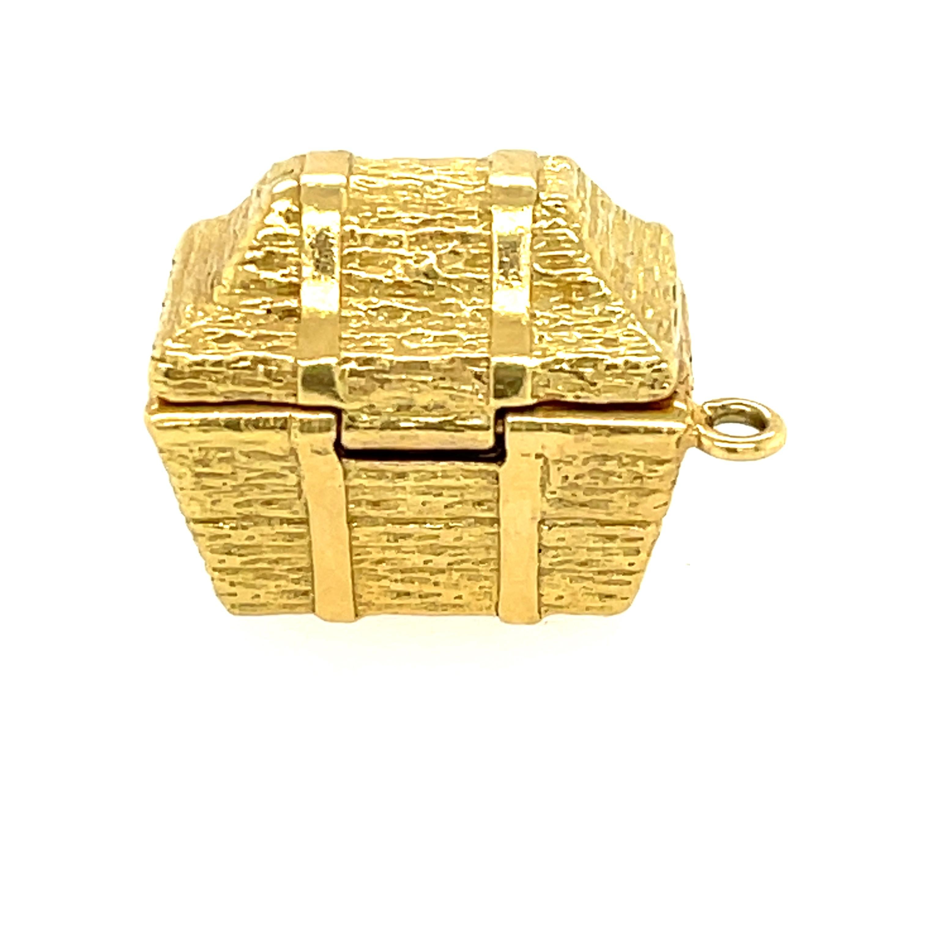 A charming vintage treasure chest charm that hinges open to reveal two colored sapphires and a diamond by Tiffany & Co. This charm was likely made in the 1990s. The charm has a nice heft to it, and has a clever hinge that opens. The charm looks like