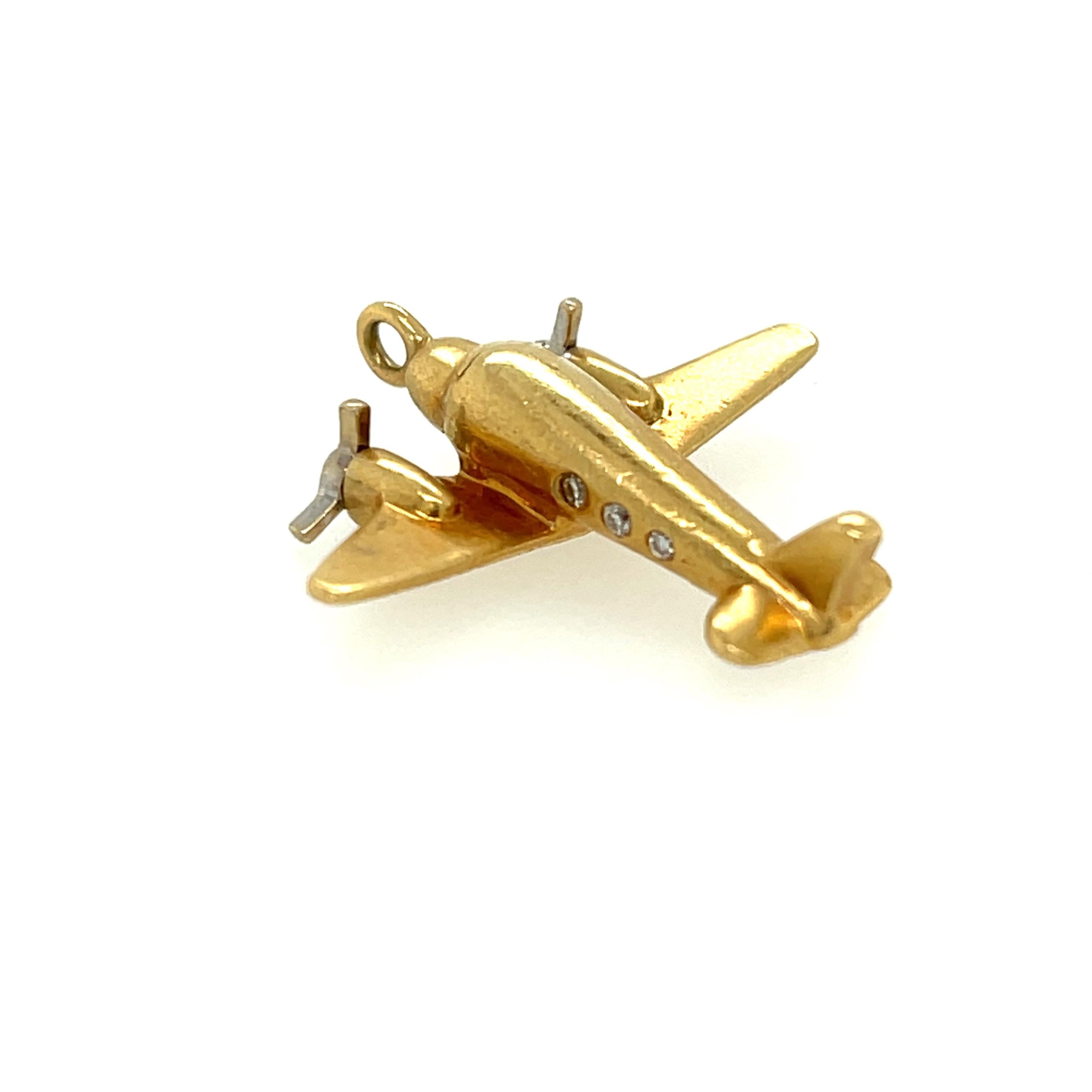 Vintage 18k model airplane charm by Tiffany & Co. Circa 1990. The charm has small diamonds set in the plane as windows. The charm has moveable propellers and is a vintage model plane. The charm is 3/4 inch long. It is stamped T & Co. 750. It weighs