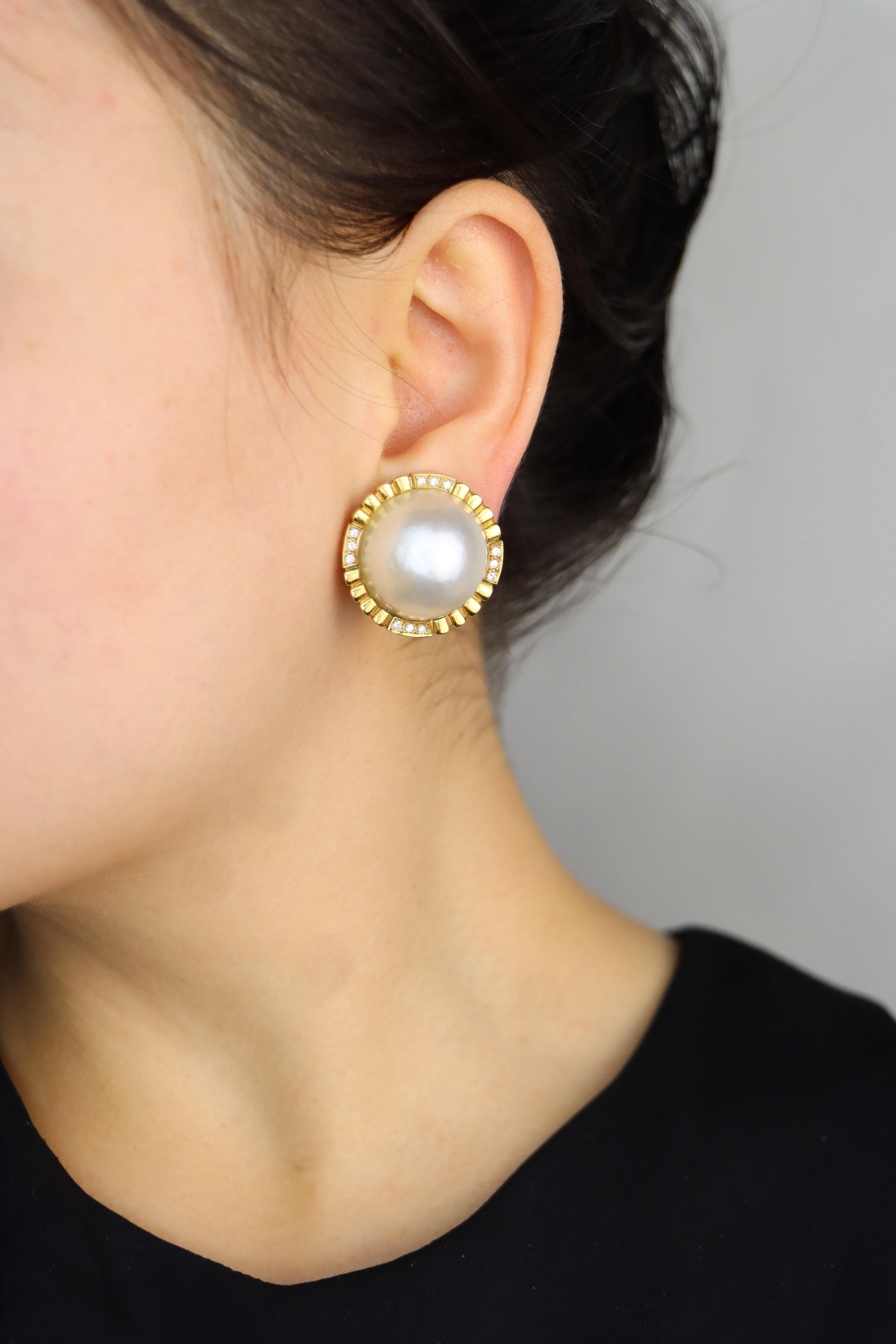 Pendientes vintage Tiffany & Co. de oro de 18 quilates con diamantes y perlas
Con lustrosas perlas blancas rodeadas de diamantes blancos  

Dimensiones aproximadas:  
2,7 cm (Anchura)  
30,1 gramos de peso  

Diseño del siglo XX  
Identificador