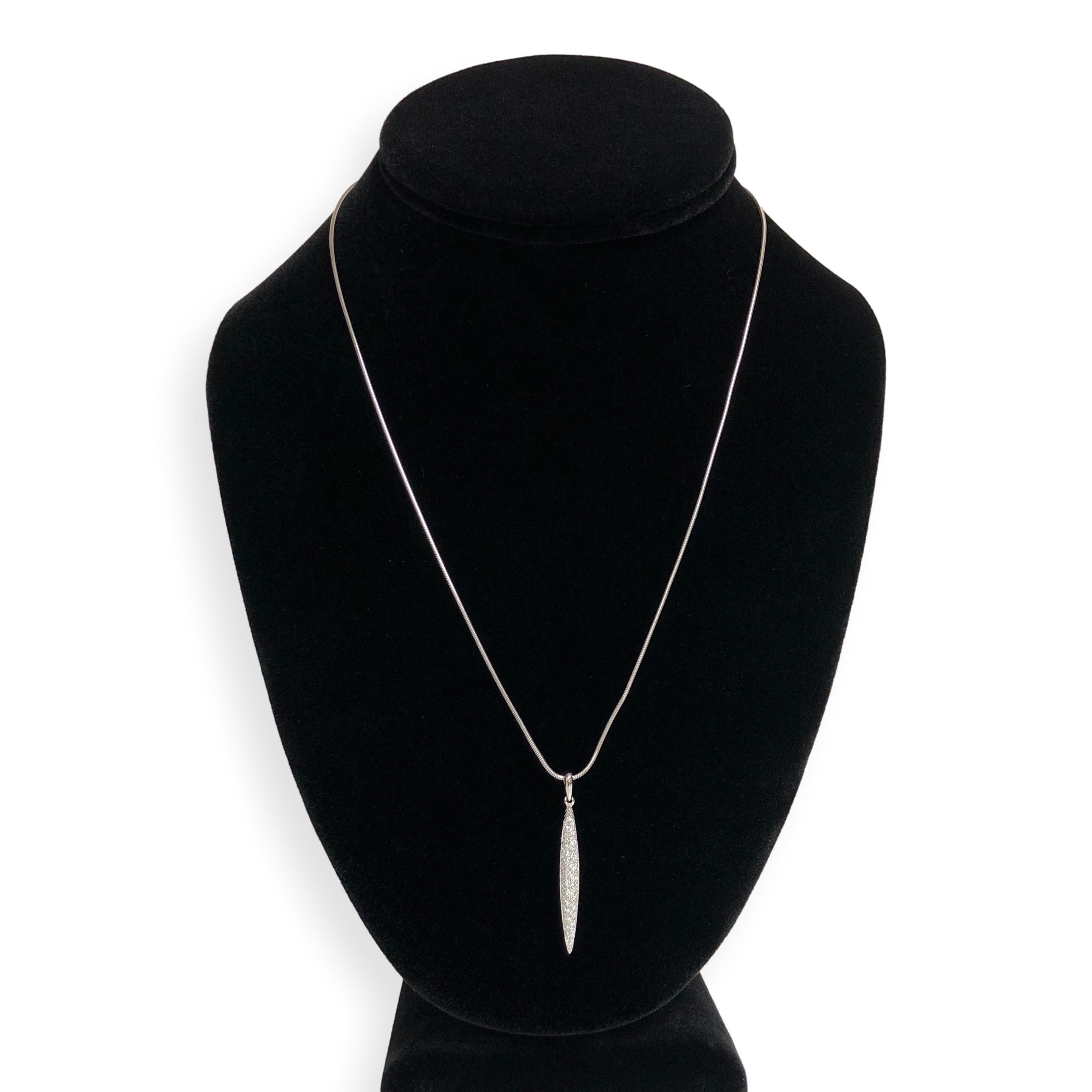 This vintage Tiffany & Co. pendant necklace features a sleek feather-inspired design crafted in 18K white gold. The tapered pendant is pavé-set with 80 round brilliant diamonds totaling approximately 0.50 carats, displaying F color and VS clarity.