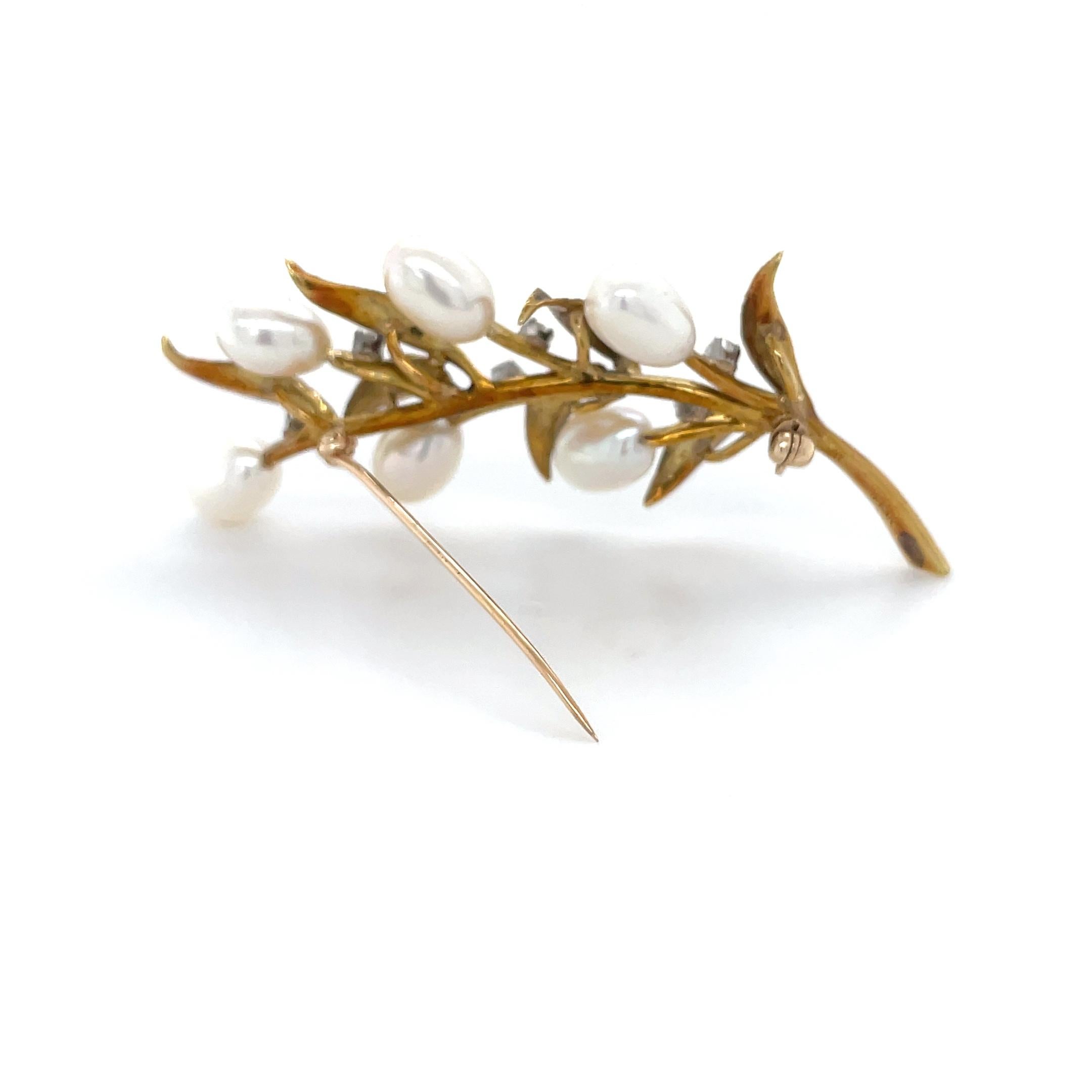 This whimsical foliate brooch by Tiffany and Co. features a six cultured pearls and round brilliant cut diamonds with textured gold leaves.

Accompanied by a Tiffany box.

Material: 18 karat yellow gold
Stamp: 18K TIFFANY.
Measurements: 2 1/2 x 1