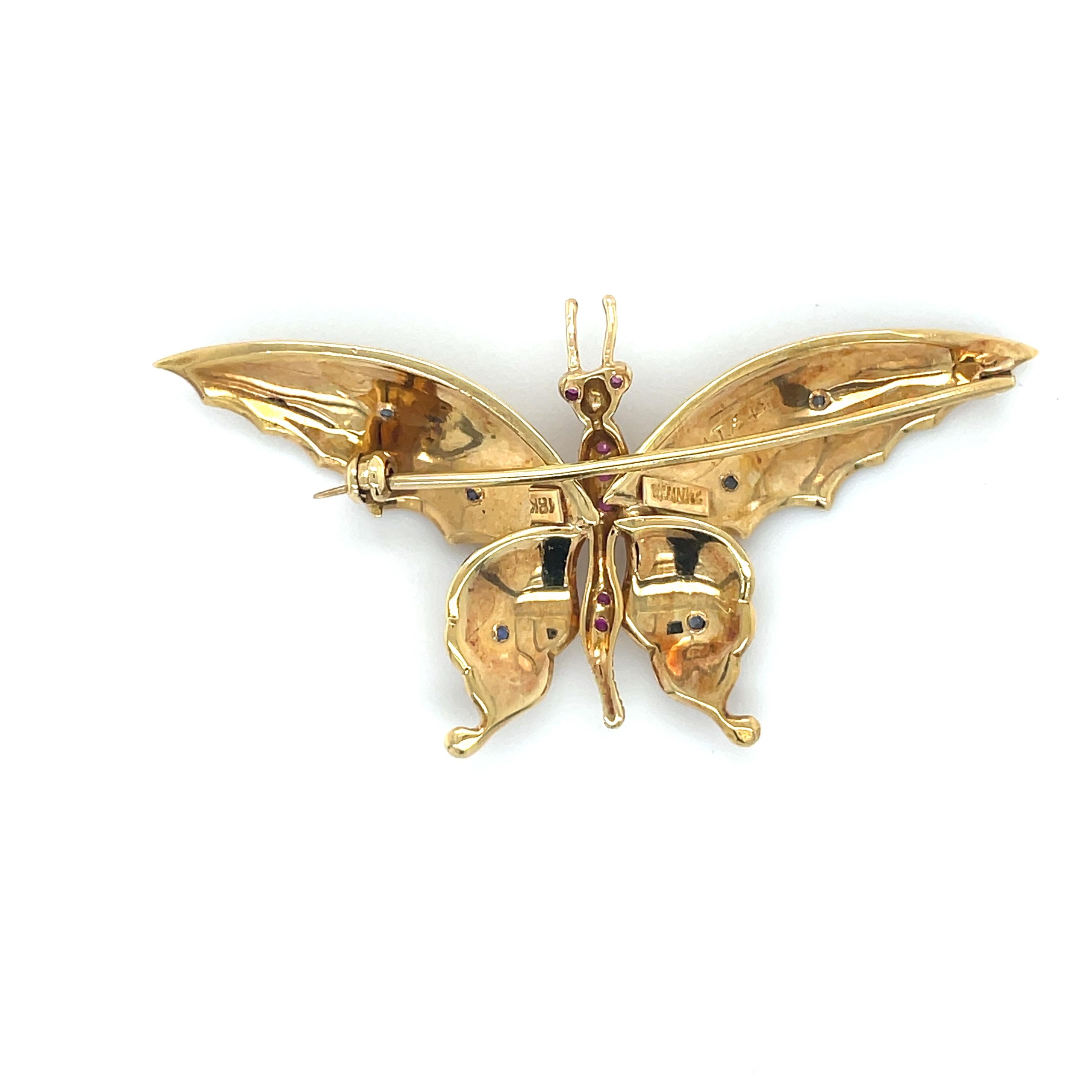Cette broche fantaisiste de Tiffany and Co. représente un papillon en pierre précieuse dont les ailes en or texturé sont ornées de saphirs et le corps de rubis. 

Accompagné d'une boîte intérieure et extérieure Tiffany.

Matière : Or jaune 18
