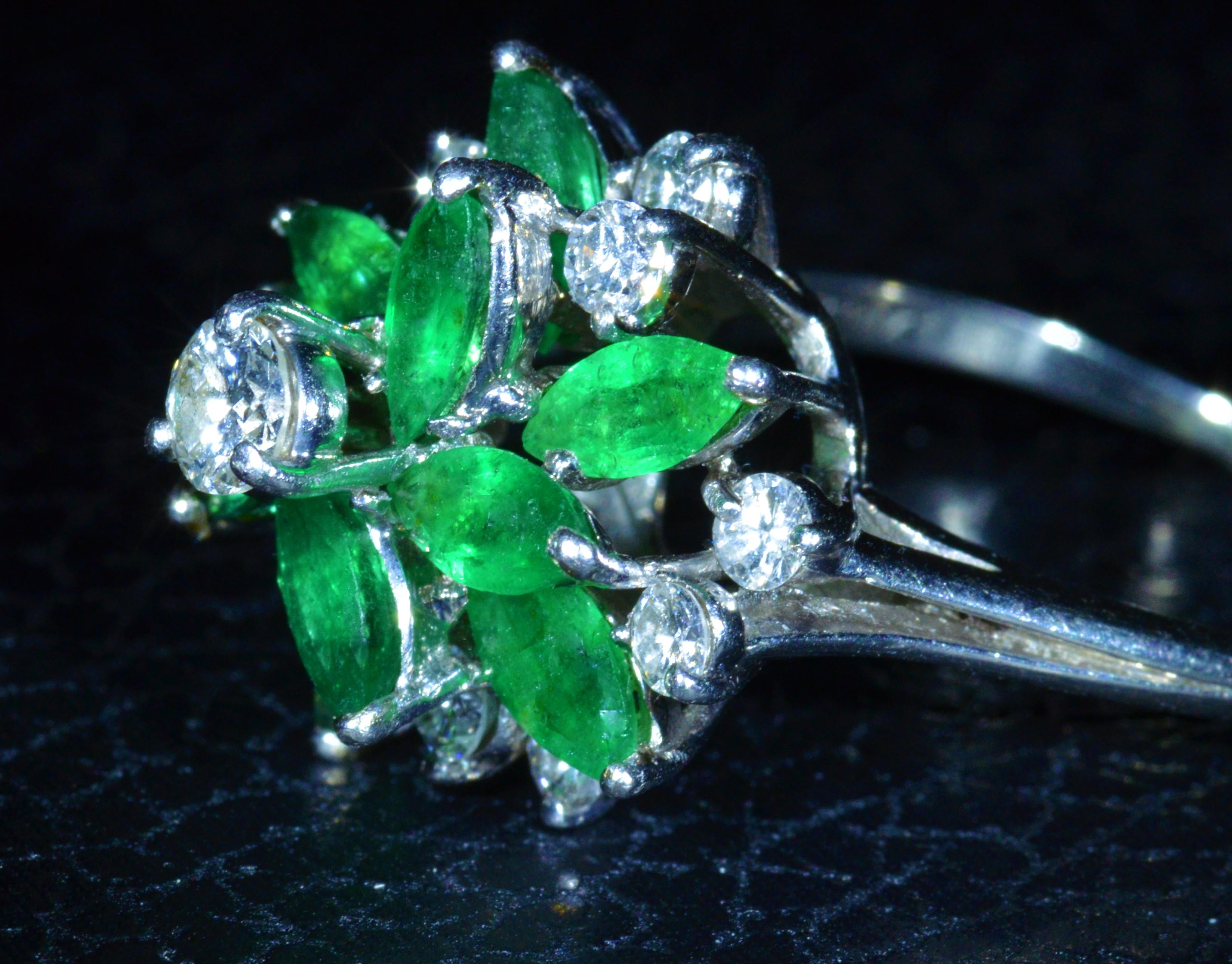 Vintage 1960's to 1970's Tiffany Emerald & Diamond Cluster Style Ring.  The ring is set with a 0.25 carat round brilliant cut diamond center stone.  Surrounding the center are 0.60 carats total weight by measurement of diamonds and 2.50 carats total