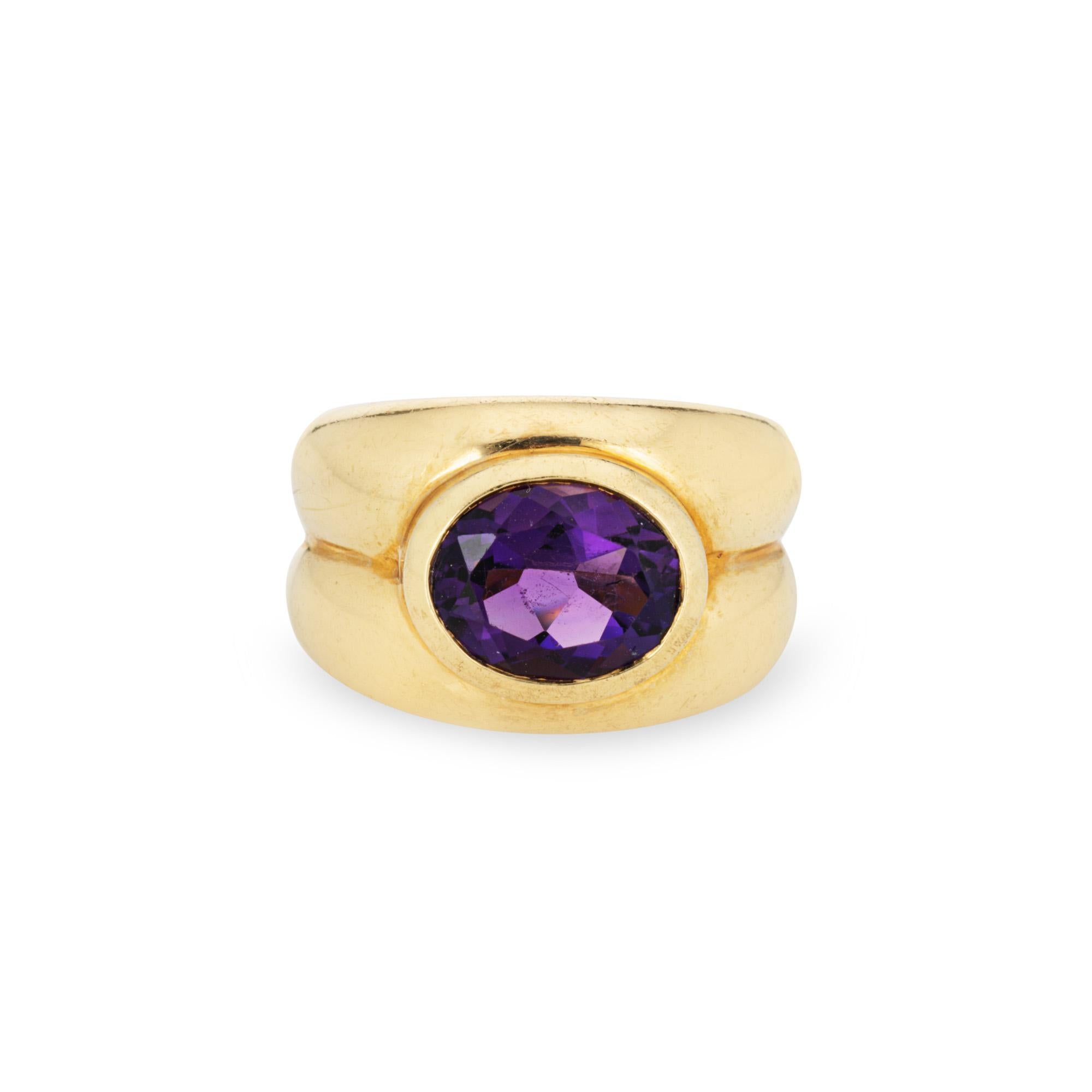 Vintage Tiffany & Co amethyst ring crafted in 18 karat yellow gold (circa 1980s).  

Faceted oval cut amethyst measures 9mm x 7.5mm. The amethyst is in good condition and free of cracks or chips. 

The wide band is set with a rich royal purple bezel