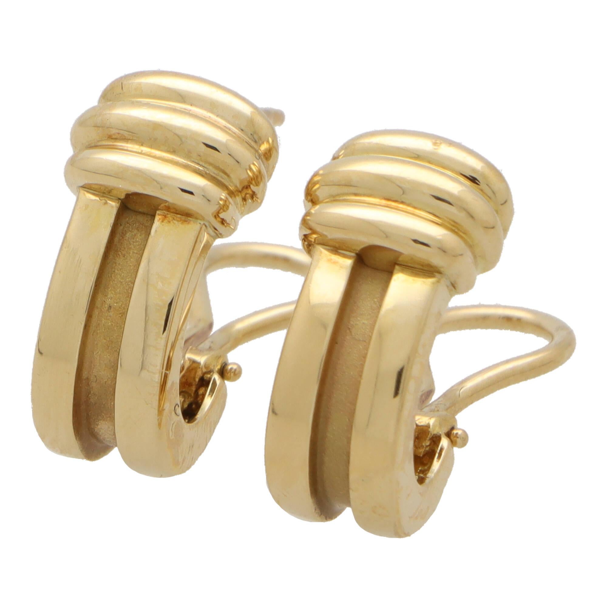 A lovely vintage pair of Tiffany & Co. ‘Atlas Grove’ earrings set in 18k yellow gold.

From a discontinued collection; each earring is composed of a ridged half hoop design; capped to the top with yellow gold ridges. Both earrings are secured to