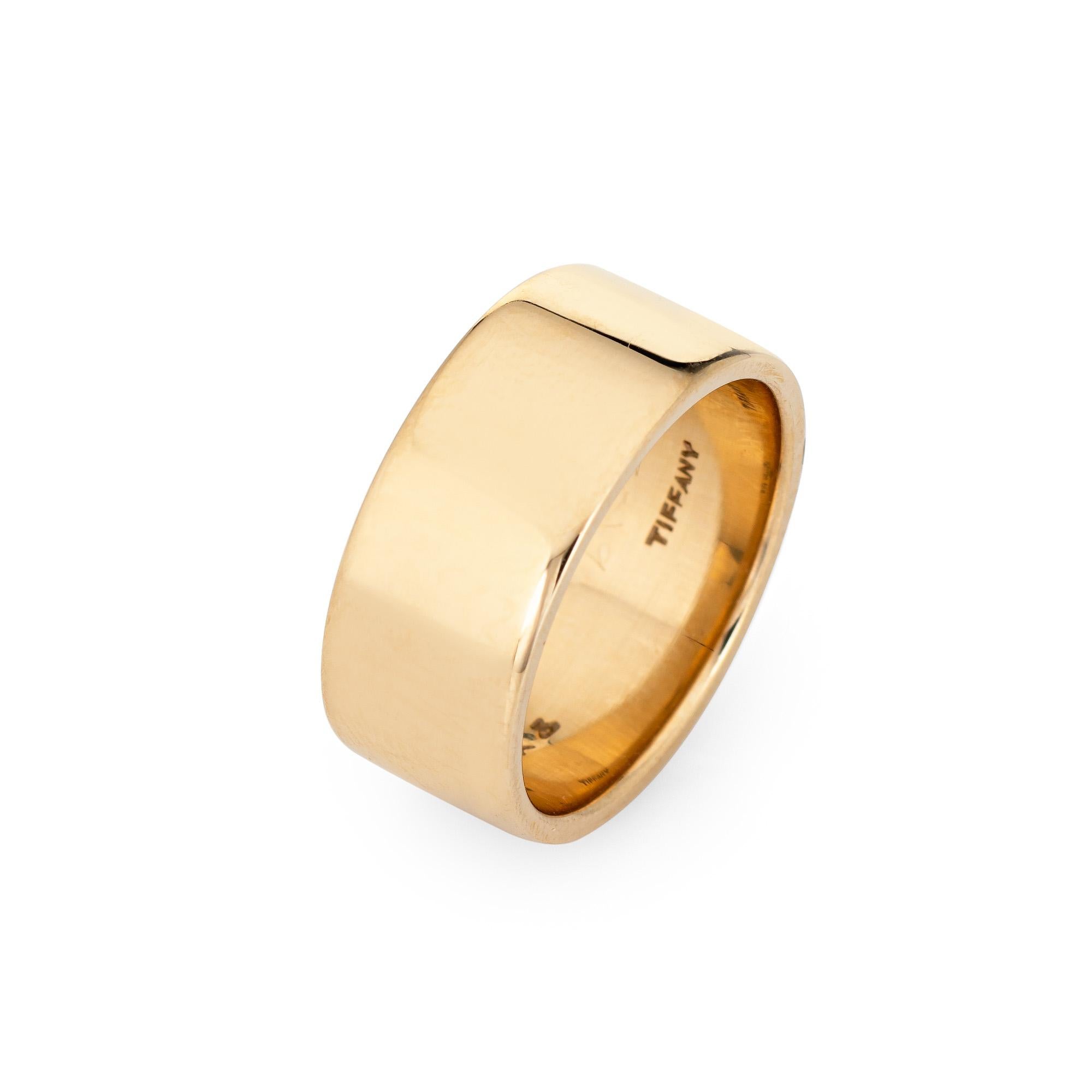 Vintage Tiffany & Co wide band ring crafted in 14 karat yellow gold (circa 1950s to 1960s).  

The 8mm wide band (0.31 inches) is great worn alone or stacked with your fine jewelry from any era. The high polish band sits flat on the finger (rises