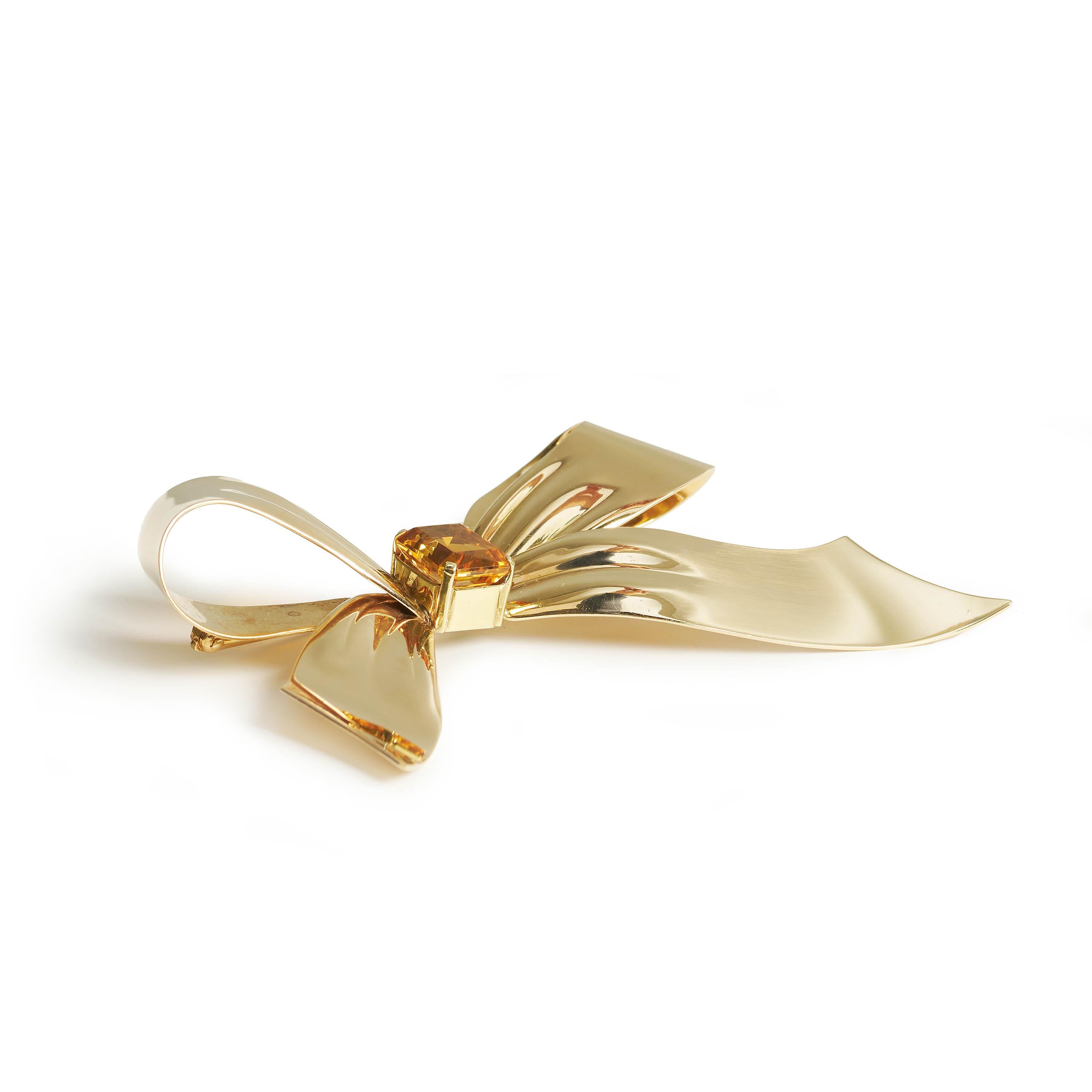 A vintage Tiffany & Co., citrine and gold bow brooch, with a scissor-cut citrine, in the place of the knot, in a four claw setting, mounted in polished 14ct gold, forming the bow ribbon, signed Tiffany & Co. on the lower ribbon, with a pin and