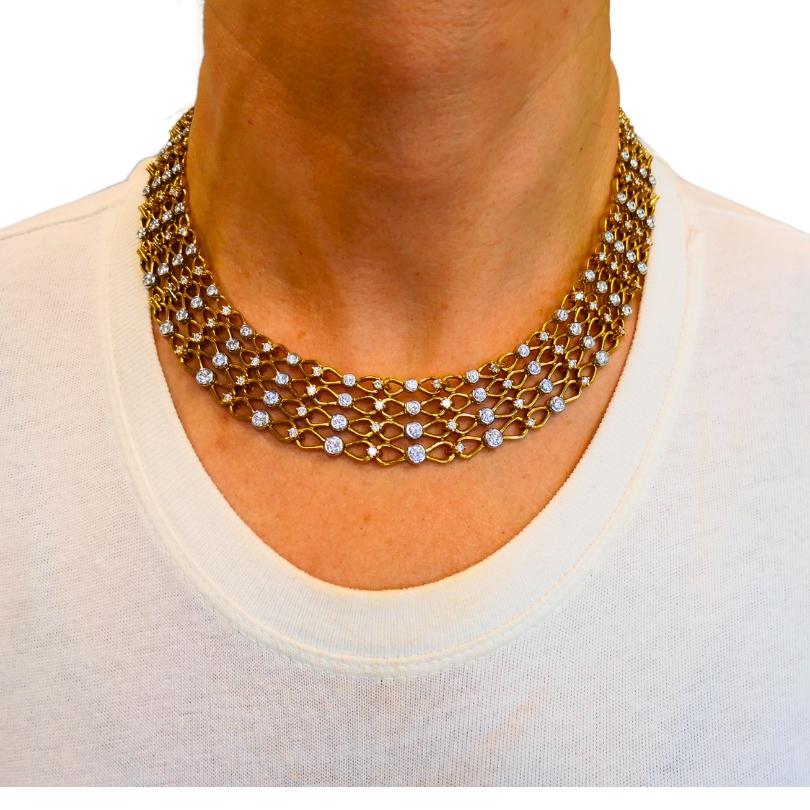 This vintage Tiffany & Co. necklace is designed in a wide collar style, crafted of 18k yellow gold with platinum settings for the diamonds. 
The openwork gold lattice forms a geometric pattern that gradually widens toward the front and narrows