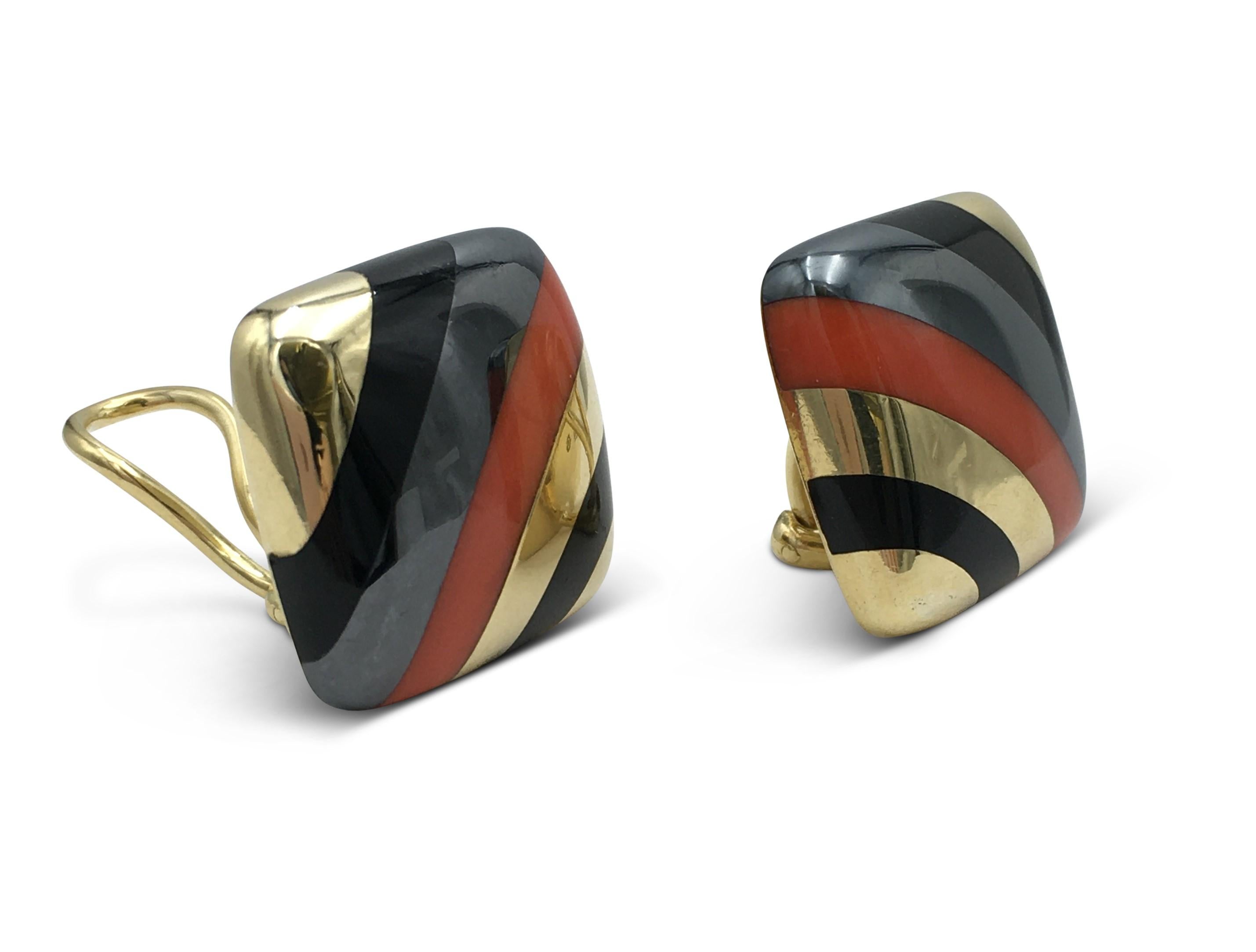 Authentic rare pair of earrings designed by Tiffany &Co. Crafted in 18 karat yellow gold, the earrings feature alternating inlaid bands of carved onyx hematite and coral stones. The earrings are clip-on with no posts. Signed T&Co, 18K, 1980. One