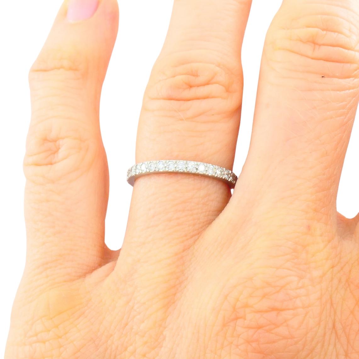 Questo classico anello a fascia di Tiffany & Co. è realizzato in platino e incastonato con una fila di diamanti tondi taglio brillante. I diamanti sono incastonati l'uno vicino all'altro in un'incastonatura a forchetta condivisa, creando una