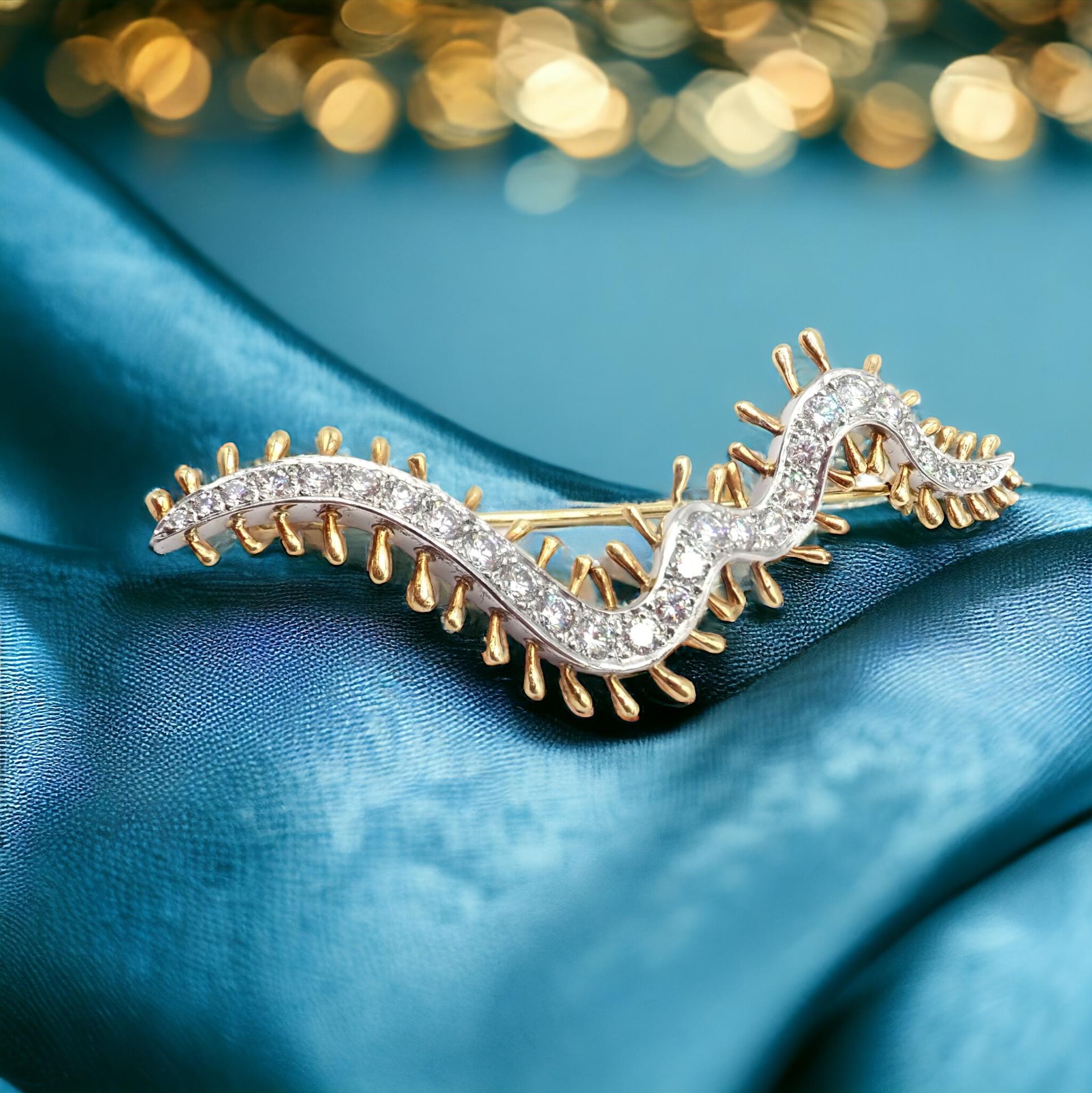 Questa spilla vintage di Tiffany & Co., creata nel 1988, è un gioiello straordinario che combina l'eleganza del platino con il calore dell'oro giallo 18 carati. 

È realizzato meticolosamente a forma di millepiedi, il che lo rende un accessorio