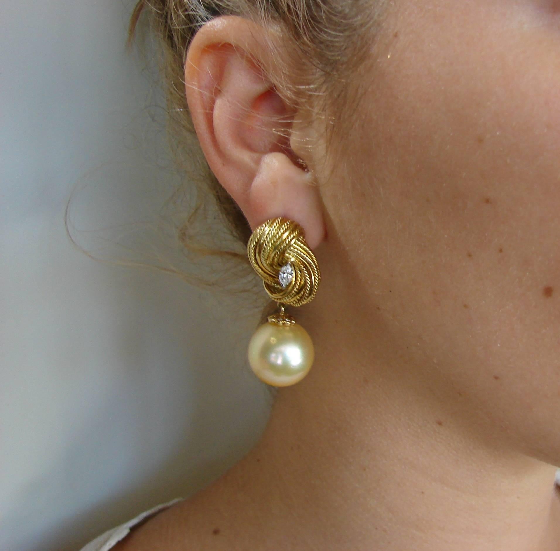 A pair of classy earrings created by Tiffany & Co. in Italy in the 1980s. It features two South Sea pearls, white and golden, set in 18 karat yellow gold setting and accented with two marquise cut diamonds (total weight approximately 0.40 carat).