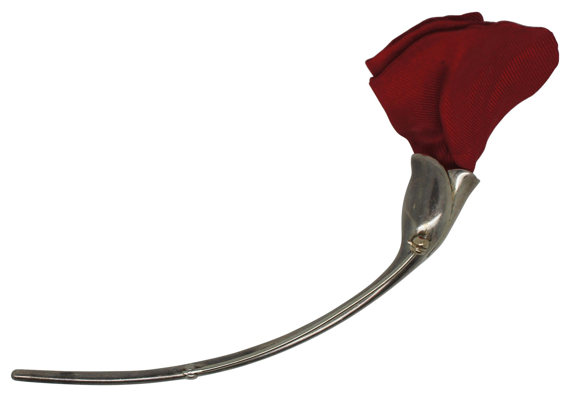 Vintage Tiffany & Co. Elsa Peretti Amapola sterling silver pin in the shape of a poppy or rose with curving stem and silk petals. Made in Spain.

According to Tiffany & Co.:
Amapola is the Spanish word for poppy. Brooch in sterling silver with