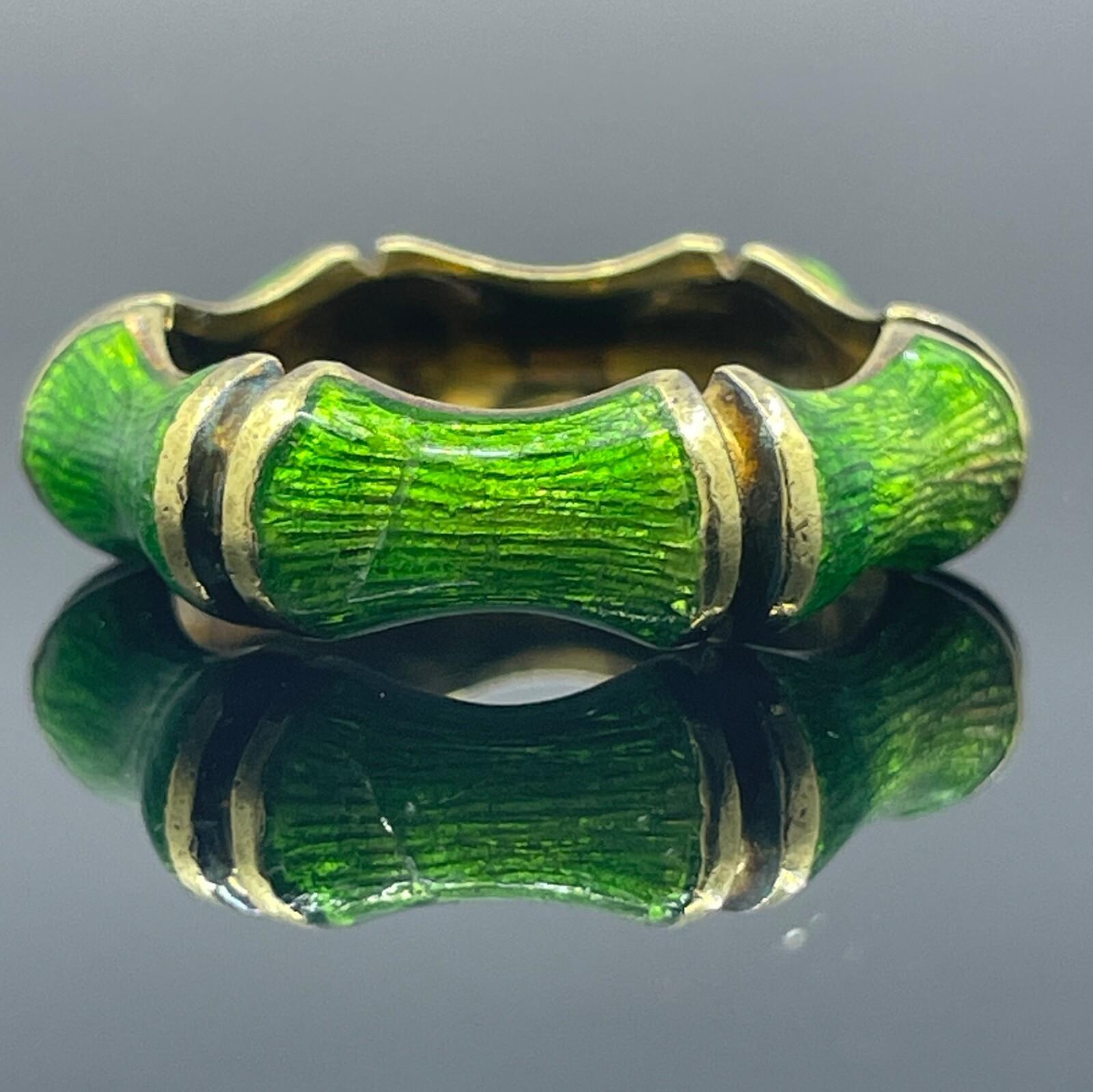 Tiffany & Co. d'epoca. Fascia di bambù con smalto verde in oro giallo 18 carati

Un design raro e da collezione, questo bracciale vintage di Tiffany & Co. presenta un motivo scultoreo di bambù in oro giallo 18 carati, rifinito a mano con un vibrante