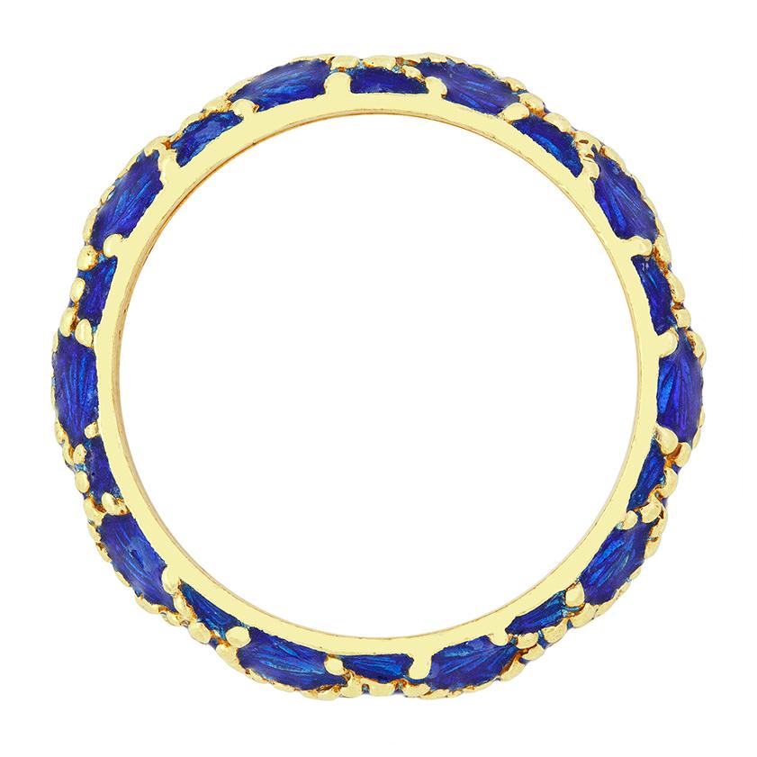 Dating back to the 1960s this delightful ring comes from the designer Tiffany & Co. Crafted in 18 carat yellow gold the band ring features elegant blue enamelling work to create a unique scale like pattern around the circumference of the