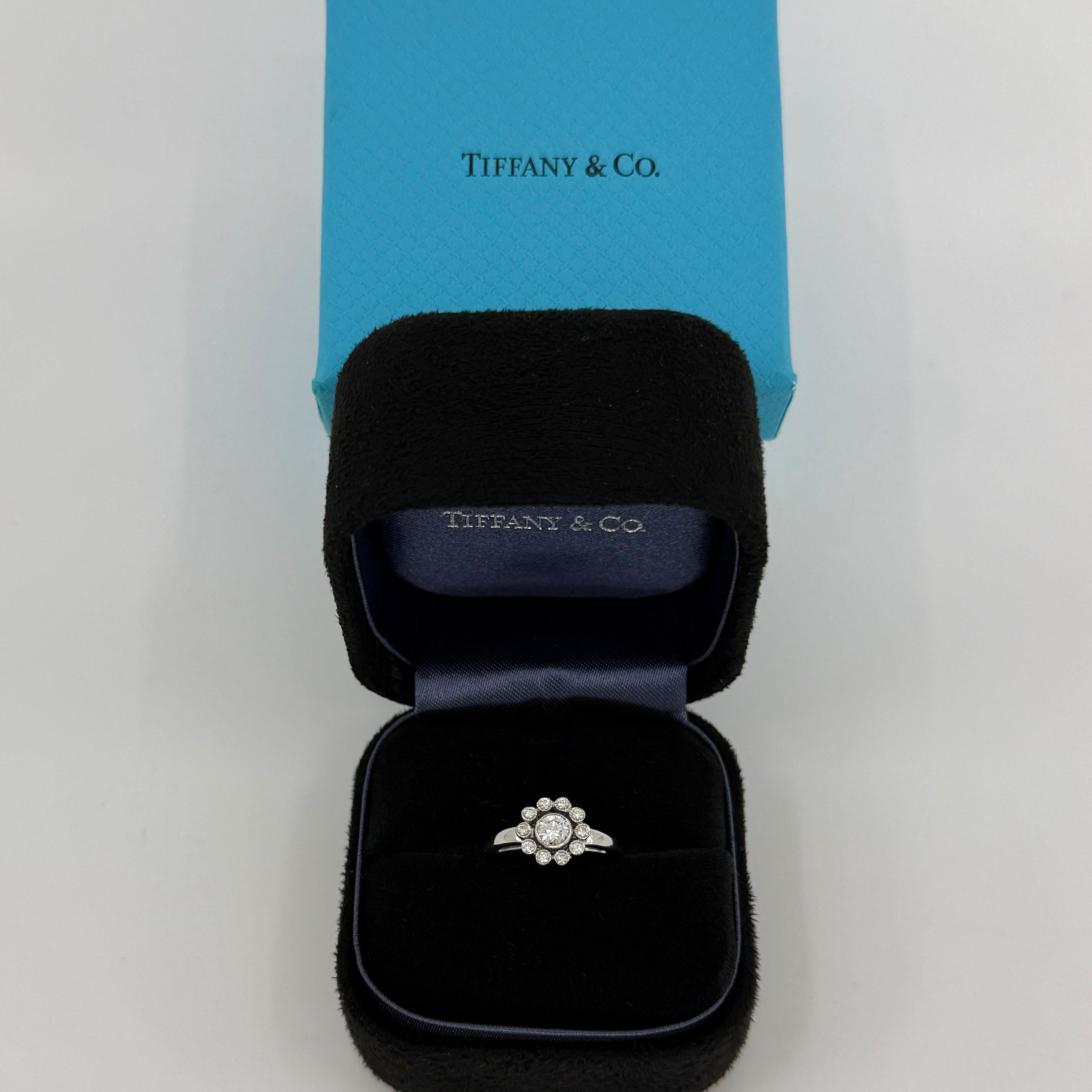 Tiffany & Co. d'epoca. Anello a fiore incantato con diamante naturale 950 in platino.

Un bellissimo anello a grappolo in platino con un diamante centrale rotondo taglio brillante di 4 mm e un'aureola di accenti di 1,5 mm. Colore, limpidezza e