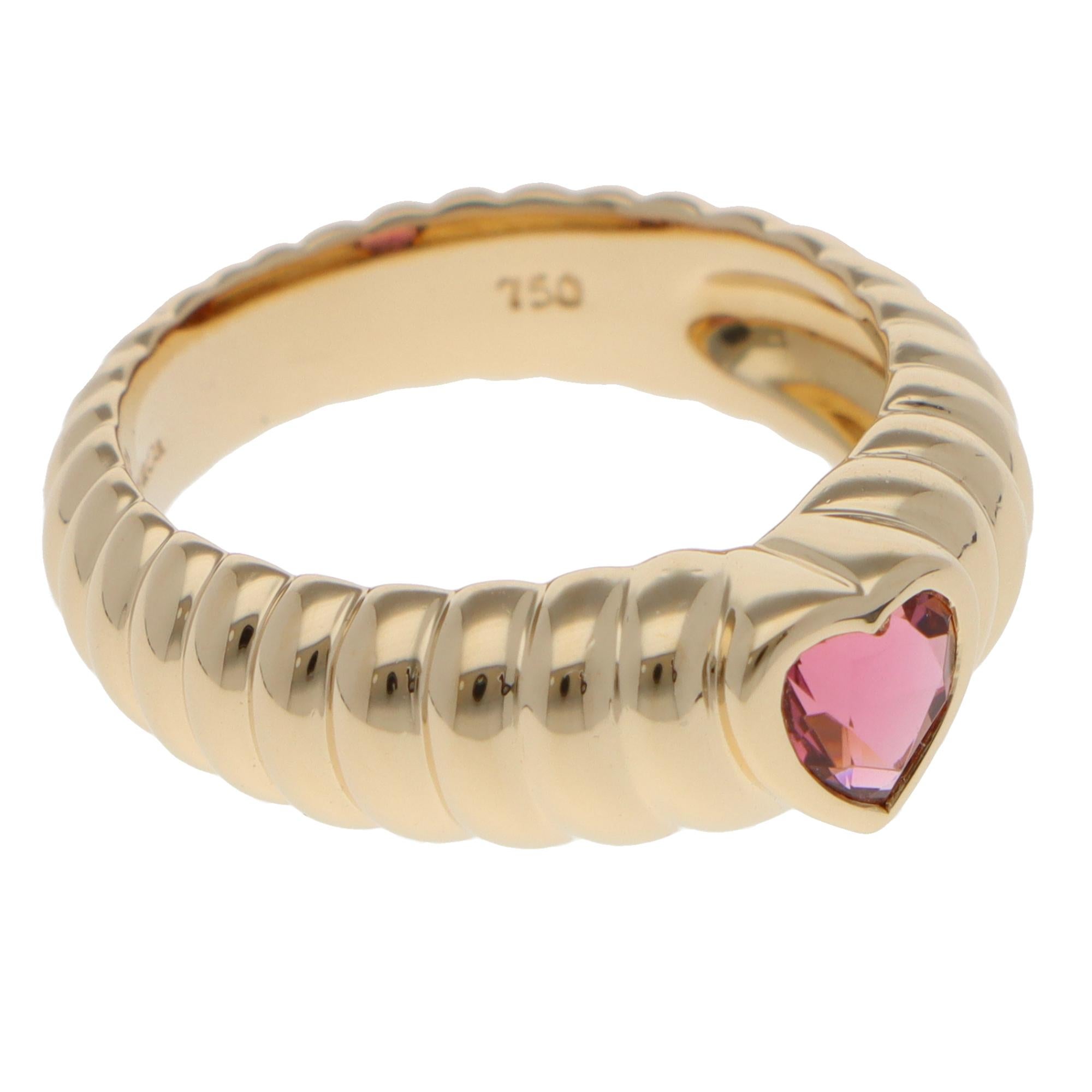 Un elegante anello vintage con tormalina rosa dell'amicizia di Tiffany & Co. incastonato in oro giallo 18 carati.

L'anello è composto da una tormalina rosa brillante a taglio misto a forma di cuore, incastonata in una fascia d'oro giallo a coste.