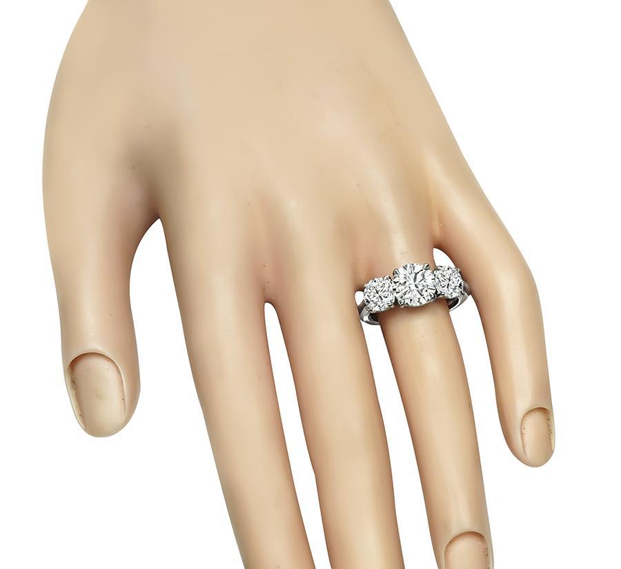 This is a stunning platinum engagement ring by Tiffany & Co. The ring is centered with sparkling GIA certified round cut diamond that weigh 2.01ct. The color of the diamond is H with VS1 clarity. The center diamond is accentuated by dazzling GIA