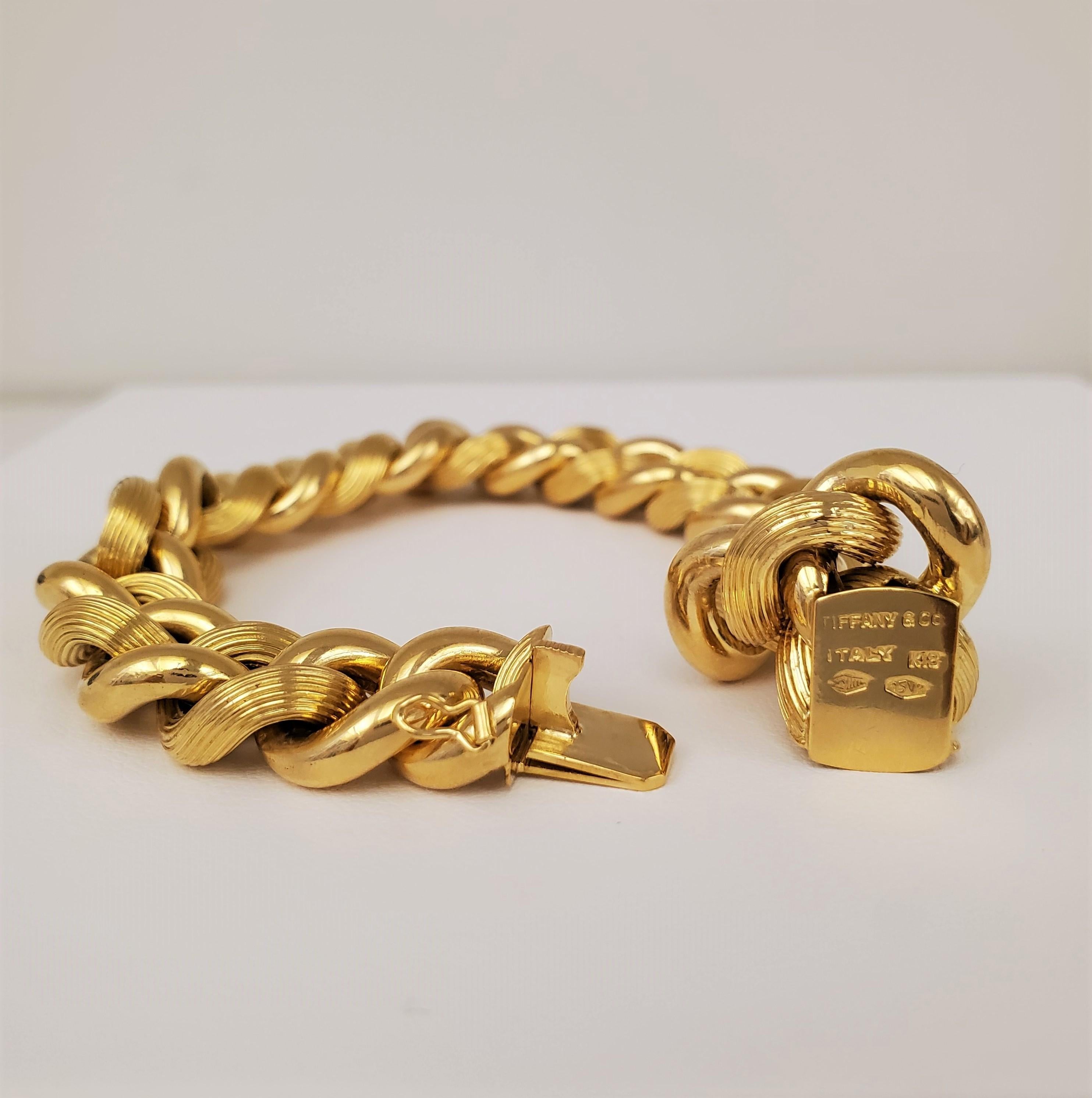 Authentic classic Tiffany & Co. high polish link bracelet features alternating textured and smooth links. Crafted in 18 karat yellow gold. Signed Tiffany & Co., Italy,  K18, 750. The bracelet measures 7 1/2 inches in length. Does not come with