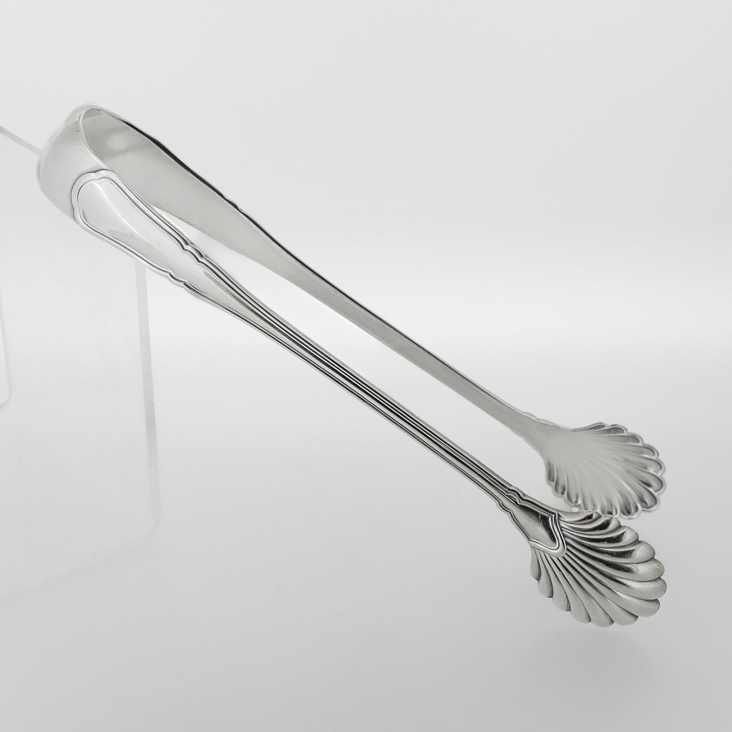 Un buen par de pinzas de plata vintage para el hielo o el azúcar.

En plata de ley.

De Tiffany & Co.

Con cuencos en forma de concha de vieira.

Marcado en el interior para Tiffany & Co. / Sterling / 925 / Italia / 20 AL.

¡Unas pinzas de Tiffany