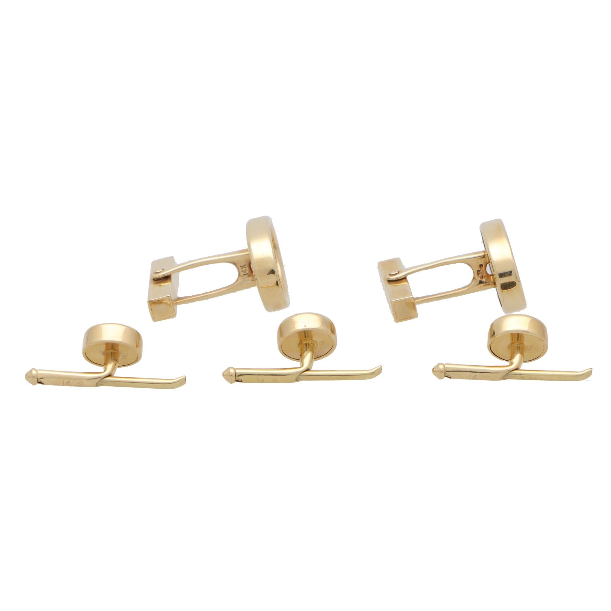 An extremely stylish vintage Tiffany & Co. cufflink and stud dress set in onyx and 14k yellow gold. 

The set is composed of a pair of oval swivel back cufflinks set centrally with an oval piece of jet-black onyx. The swivel back fittings allow the