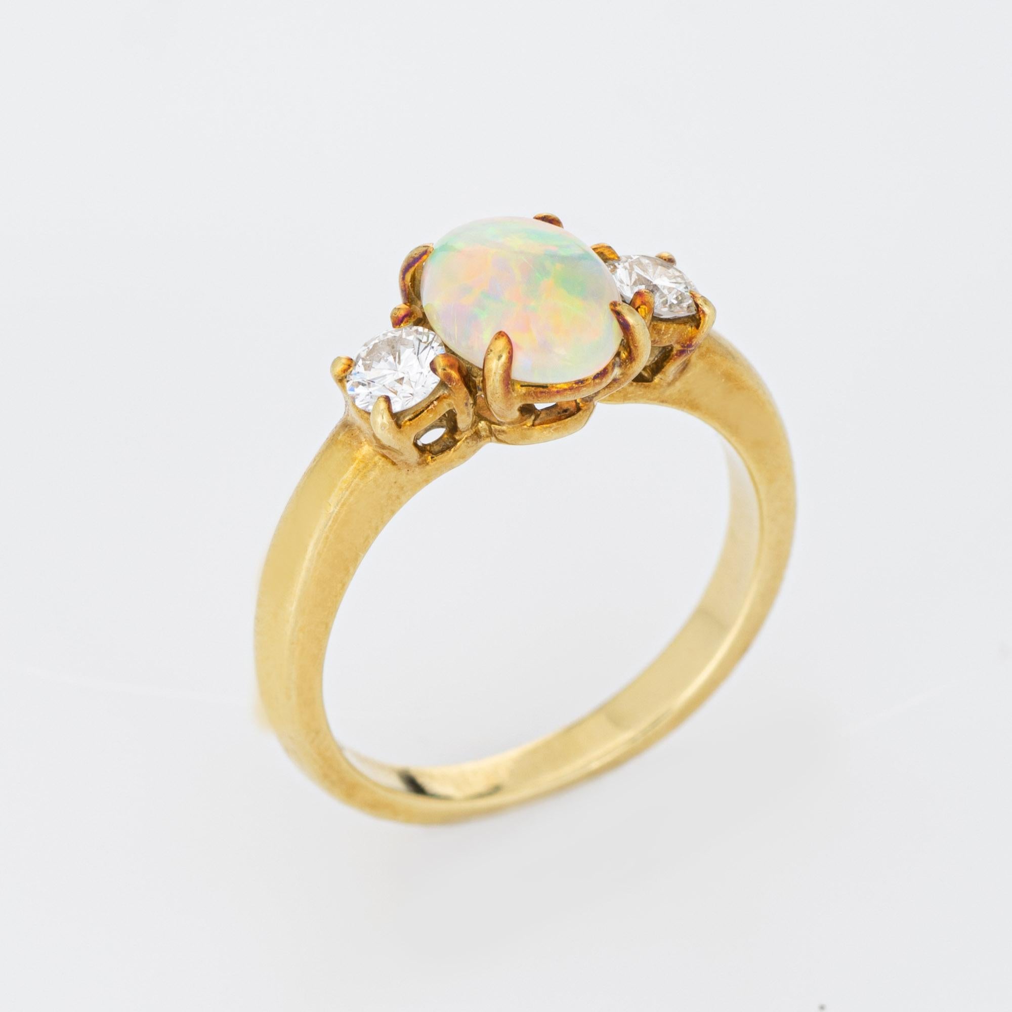 Vintage Tiffany & Co opal & diamond ring crafted in 18 karat yellow gold (circa 1980s to 1990s).  

Natural opal measures 8mm x 6mm (estimated at 1.25 carats), accented with two estimated 0.15 carat round brilliant cut diamonds. The total diamond