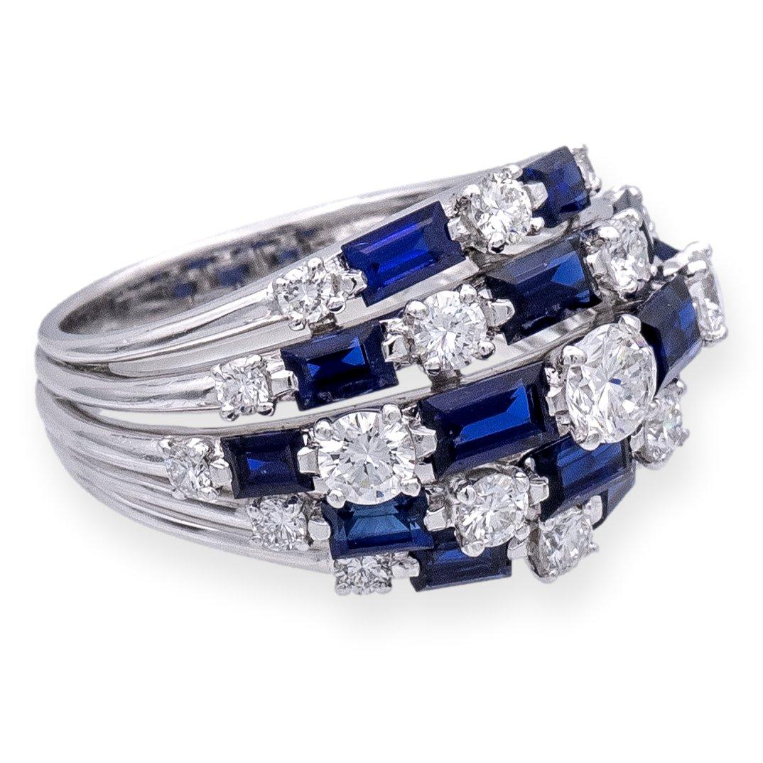 This stunning Vintage Tiffany & Co. dome-style cocktail ring showcases exceptional craftsmanship in platinum, adorned with a mesmerizing display of diamonds and sapphires. The 19 round brilliant cut diamonds, totaling approximately 1.18 carats, are