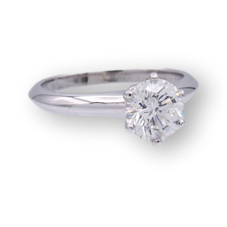 Vintage Tiffany & Co. Diamond Engagement ring finely crafted in a six prong platinum mounting featuring a 1.06 ct. round brilliant diamond center graded F color and VS1 Clarity.  Very Good cut polish and symmetry. This ring was made in 1998 and is