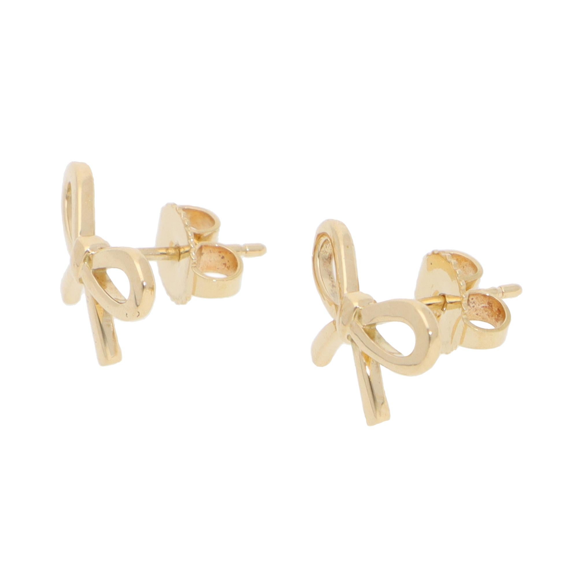 A lovely vintage pair of Tiffany & Co. ribbon bow stud earrings set in 18k yellow gold.

Each earring is composed of a bow motif, delicately handcrafted into the shape of a classic ribbon bow. The bows are set in polished yellow gold, which looks