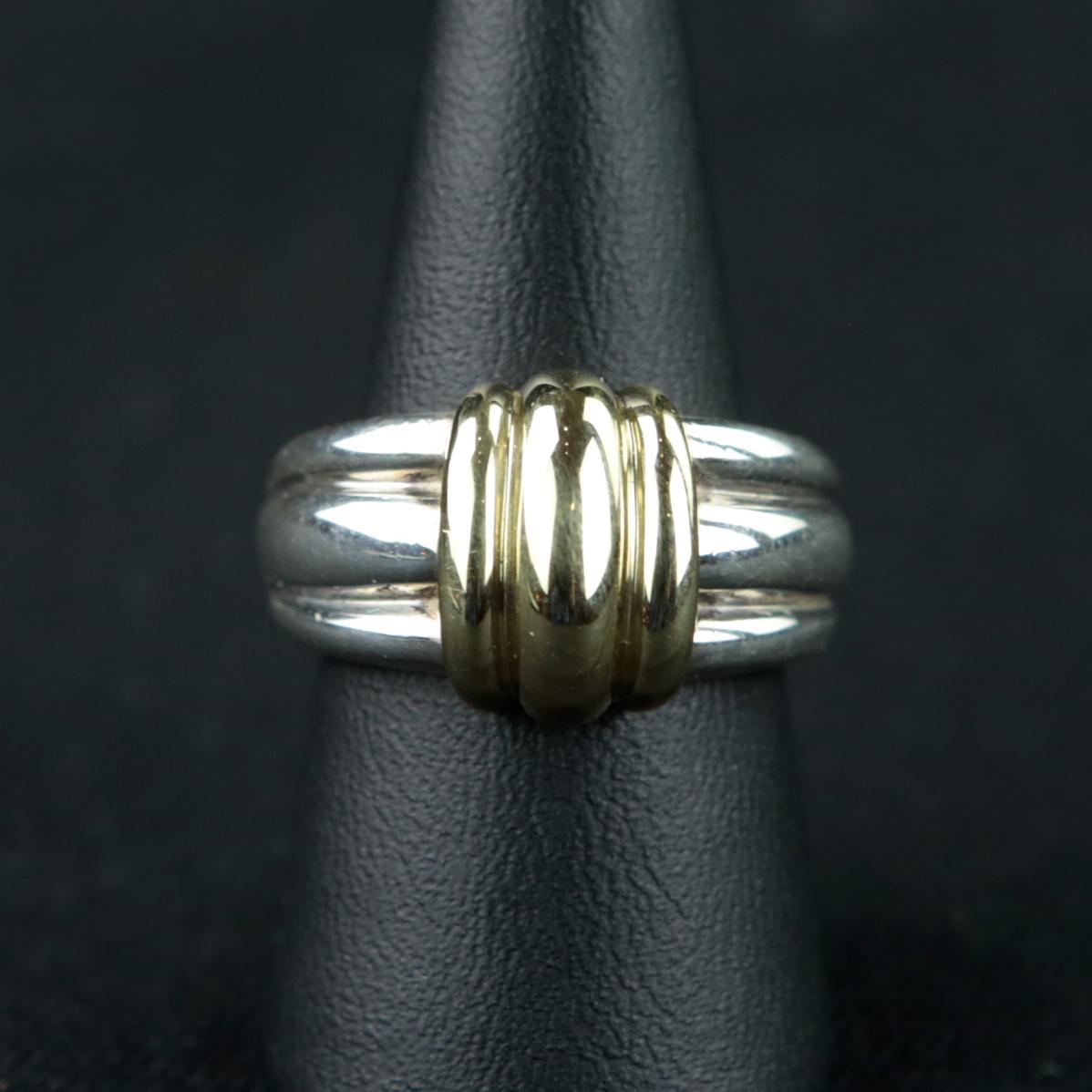 A ring from Tiffany & Co. made of 925/- sterling silver and 18 ct. yellow gold that is as special as it is designed for everyday wear. The yellow gold element is wrapped around the sterling silver ring band like a gathered band. The ring dates from