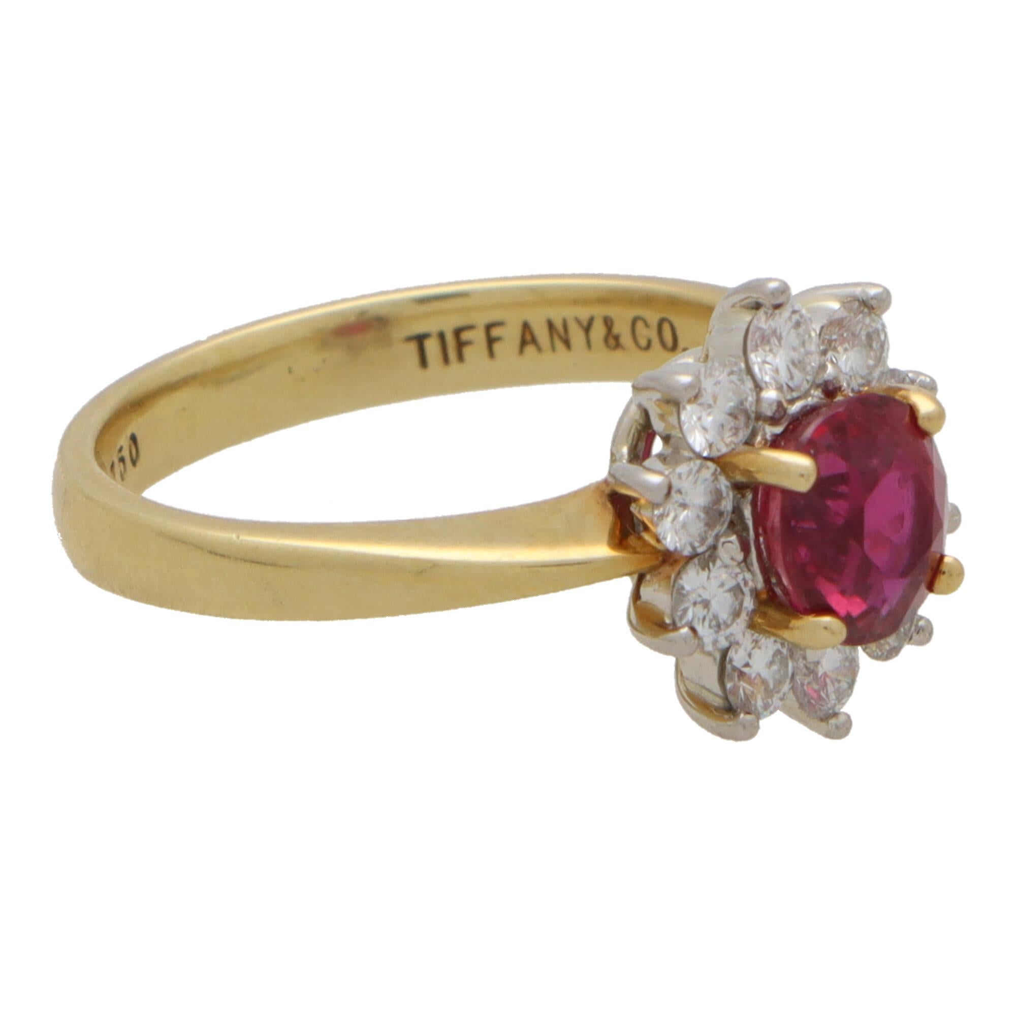 A beautiful vintage Tiffany & Co. ruby and diamond cluster ring set in 18k yellow gold and platinum.

The piece is centrally set with a vibrant oval cut ruby which is four-claw set securely. The ruby has a fantastic coloring to it and is surrounded