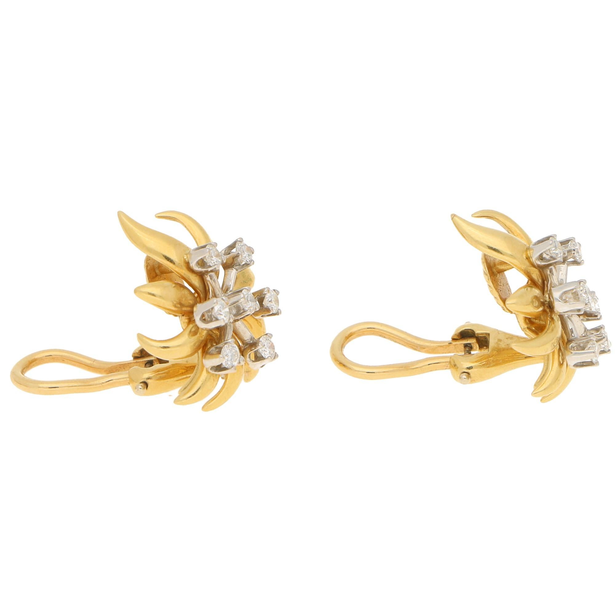 A pair of vintage Tiffany & Co. Schlumberger diamond floral earrings in 18-karat yellow gold and platinum. Each earring is designed as a smooth polished yellow gold floral motif, set with fancy round brilliant-cut diamonds stamen claw-set in