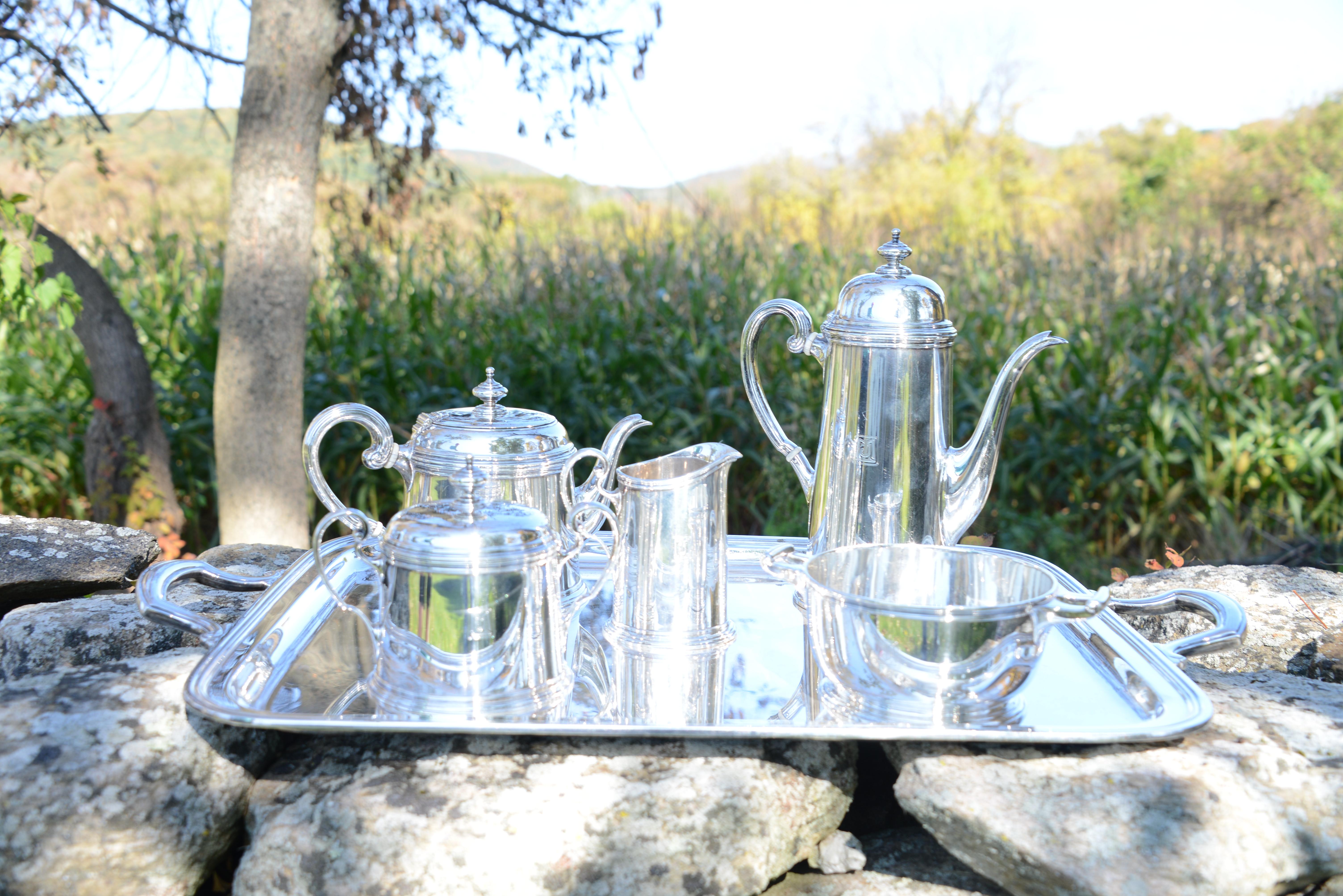 The 6 pieces of this beautiful Tiffany & Co set include a tall coffee pot, a shorter tea pot, open creamer, lidded sugar bowl, waste bowl and a rectangular tray with handles. All pieces except the tray are marked with an M, representing manufacture