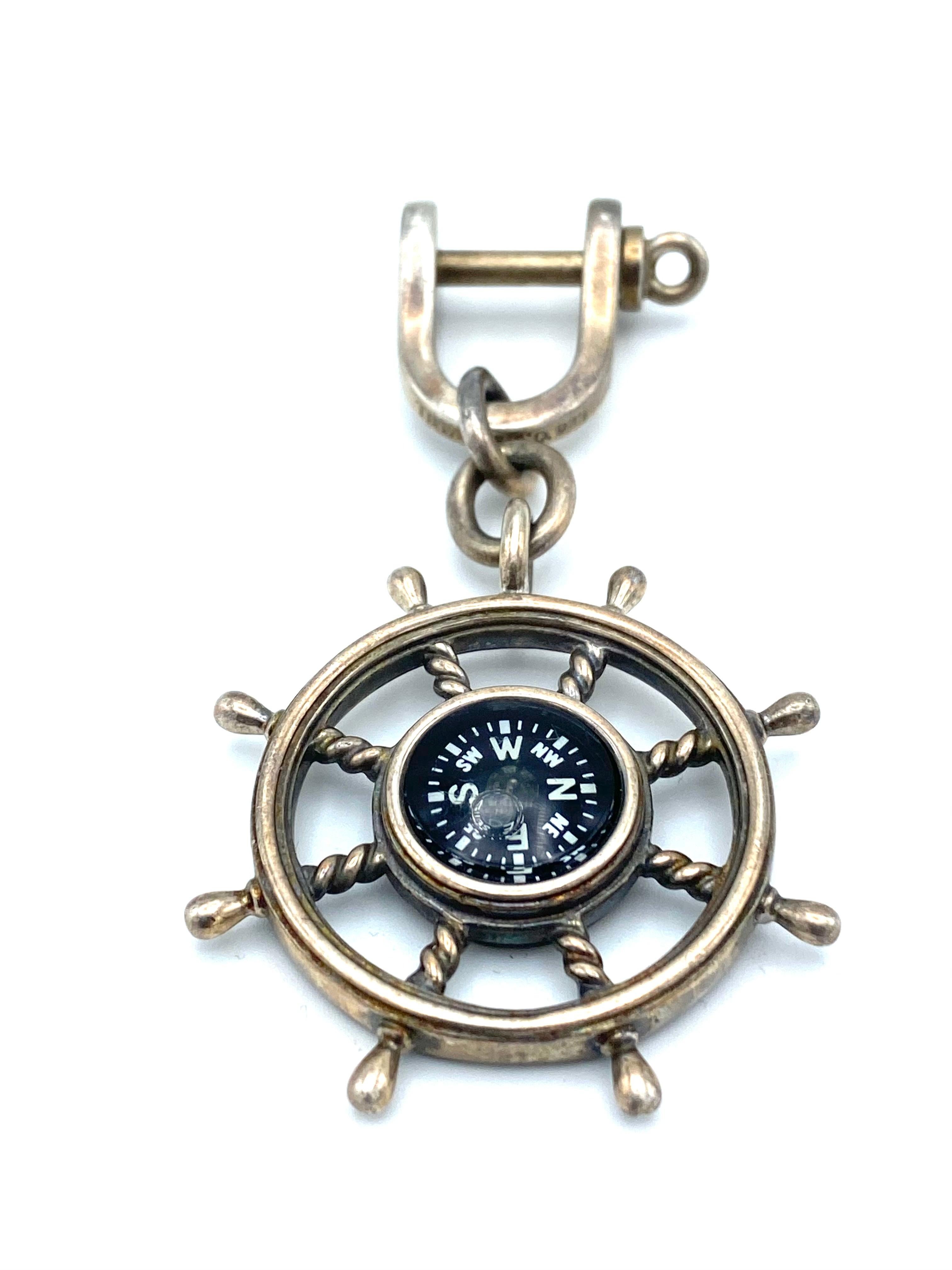Product details:

925 sterling silver and enamel compass in the ship's wheel on a key chain with screw in closure, featuring nautical motif designed by Tiffany and Company.
Signed by Tiffany & Co., stamped with 925 hallmark for sterling